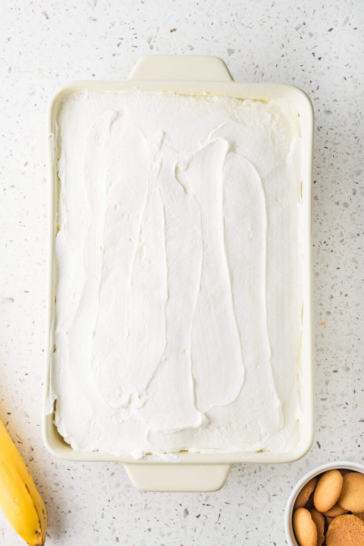 whipped cream spread over banana pudding poke cake