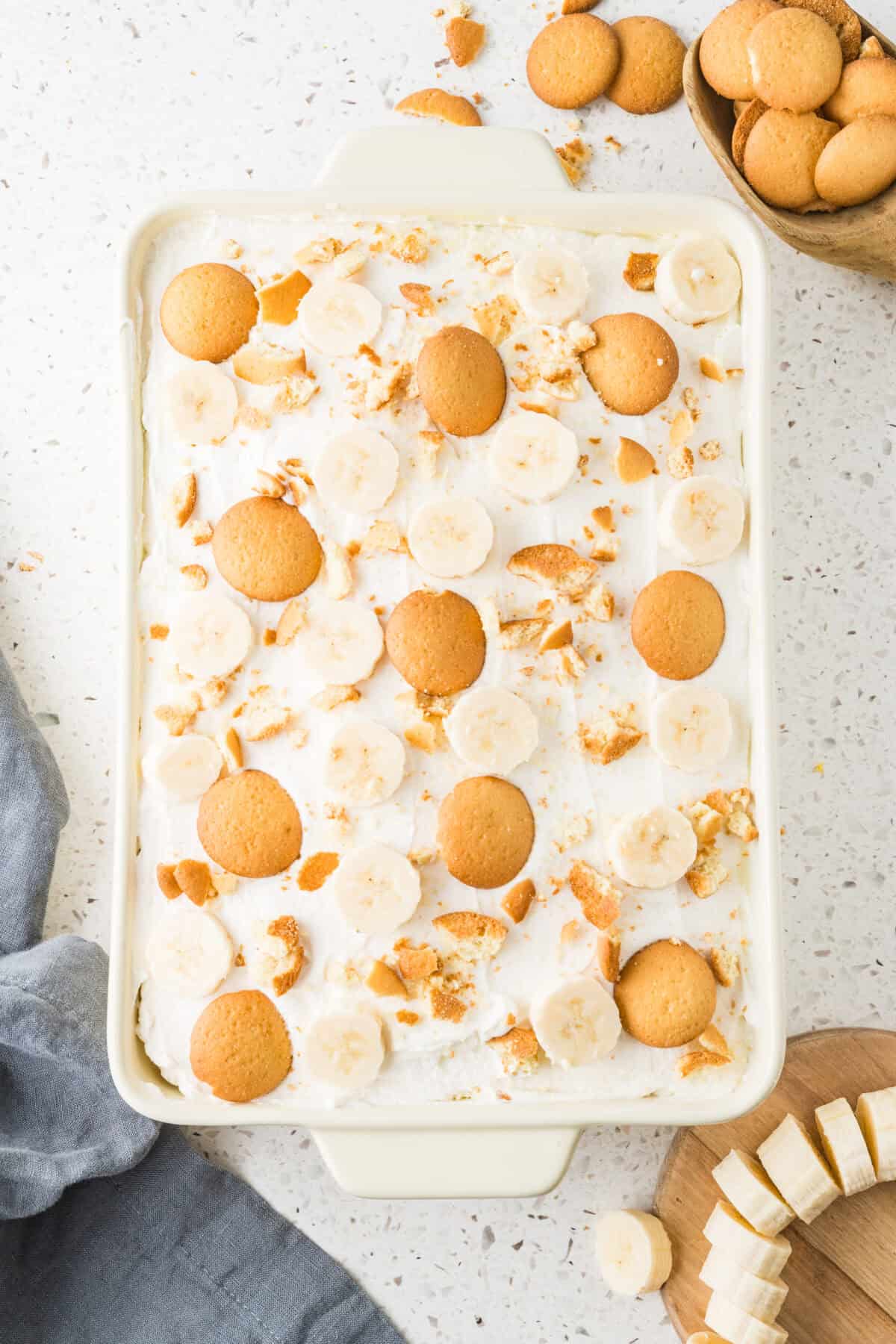 vanilla wafers and fresh banana slices on top of whipped cream on poke cake