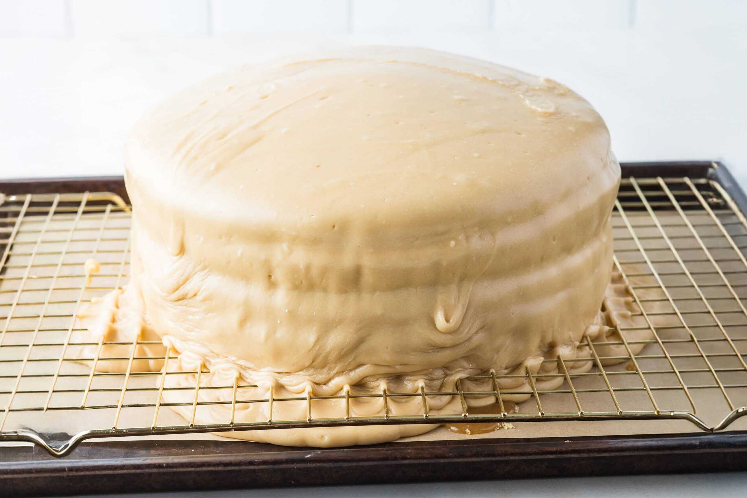 caramel frosting poured over vanilla cake layers with caramel filling
