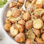 crispy garlic parmesan potatoes in a white bowl