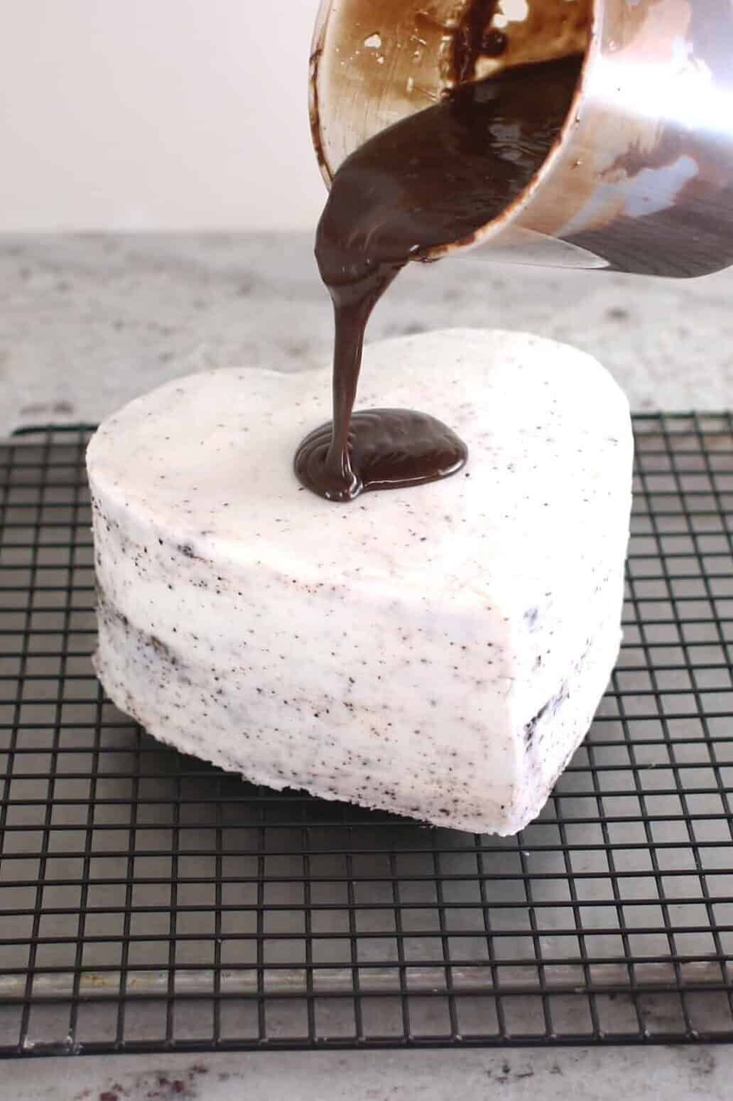 pouring ganache over cake