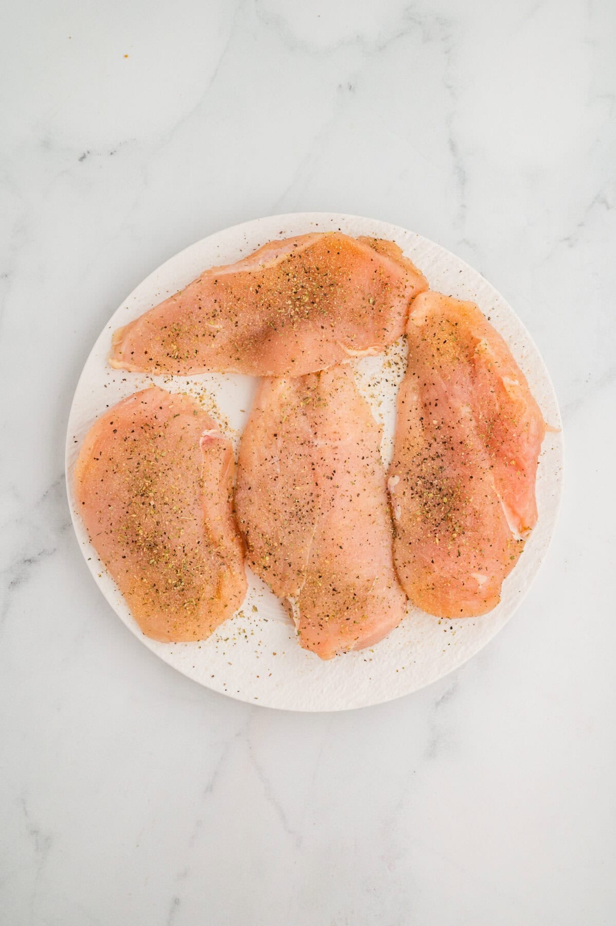 seasoned chicken breasts on a white plate
