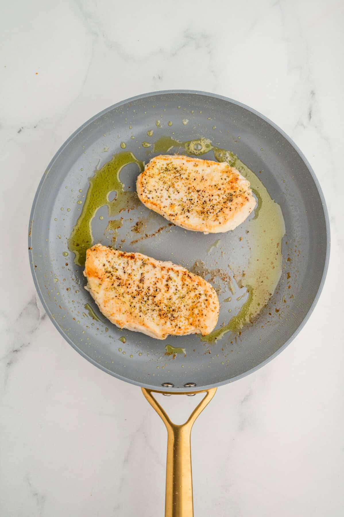 sauteing chicken breasts in a skillet
