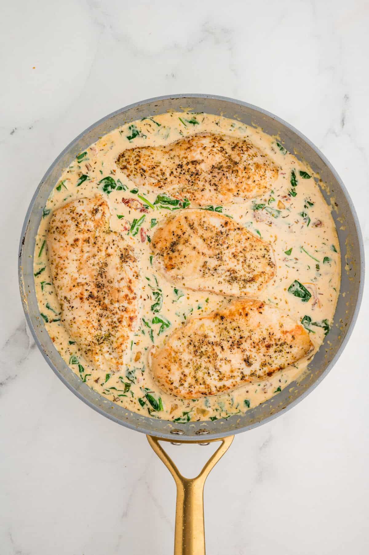 creamy tuscan chicken in a skillet