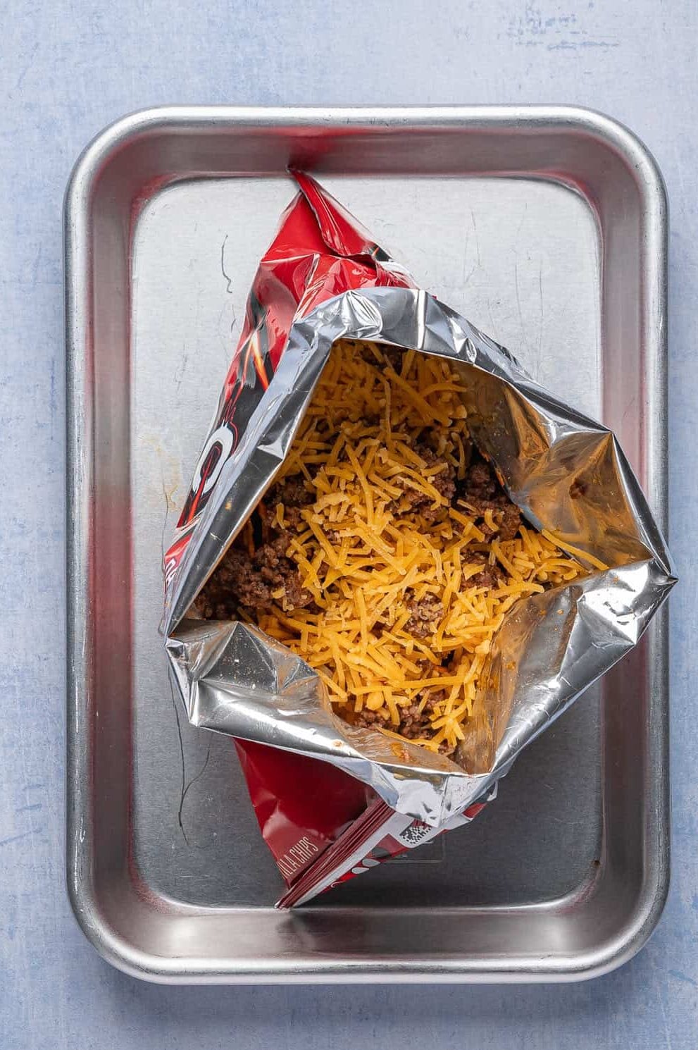 bag of doritios open with ground beef and cheese inside