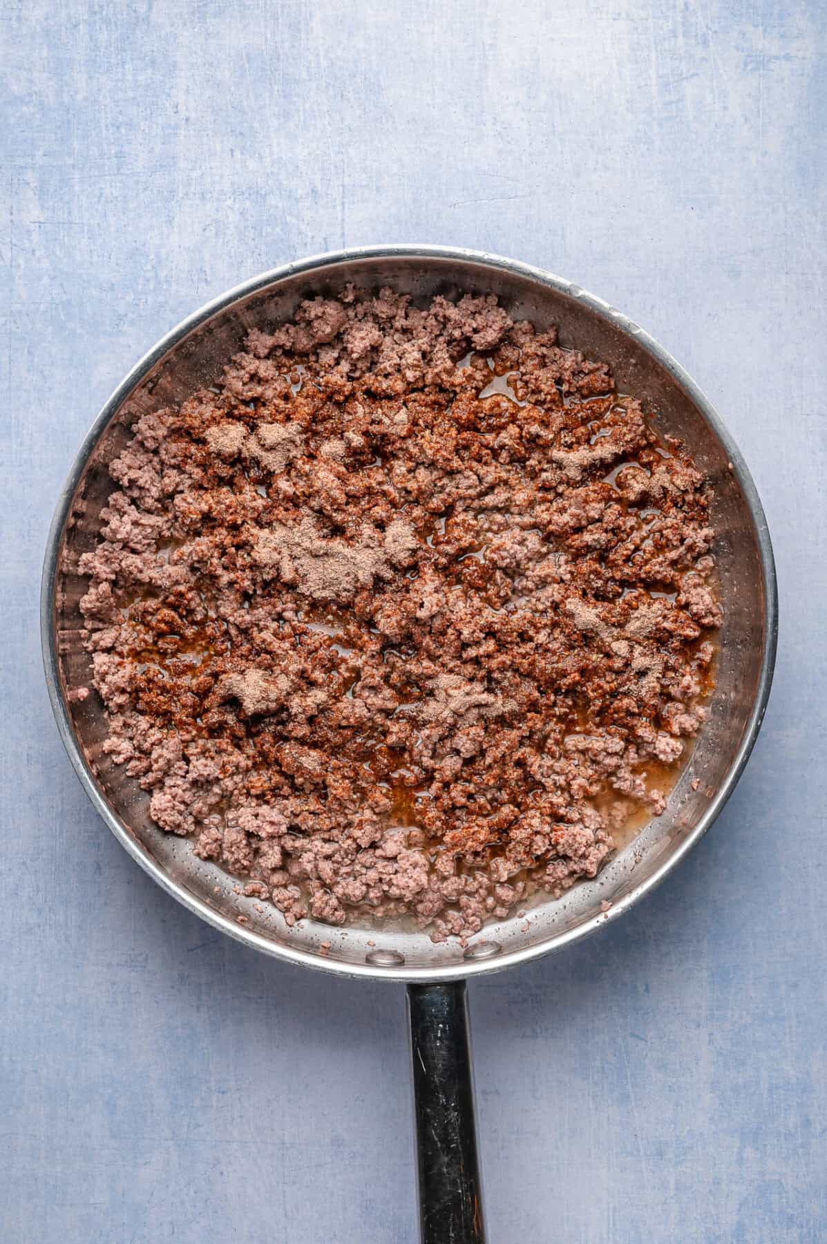 taco seasoning sprinkled over ground beef
