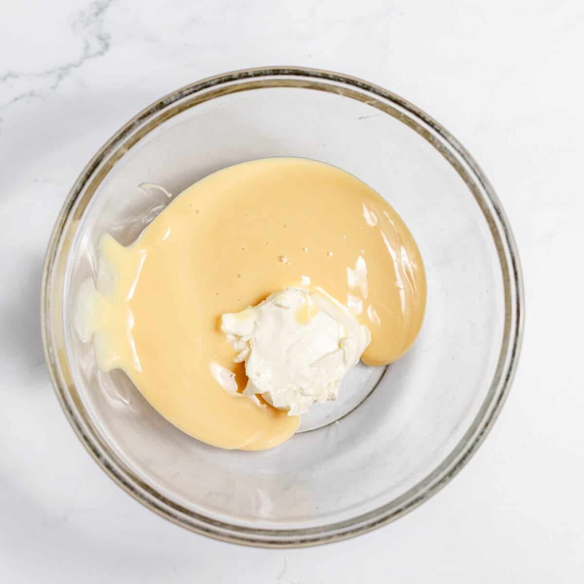 sweetened condensed milk and cream cheese in a mixing bowl