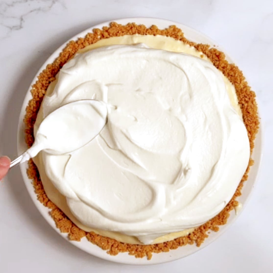whipped cream spread over orange pie