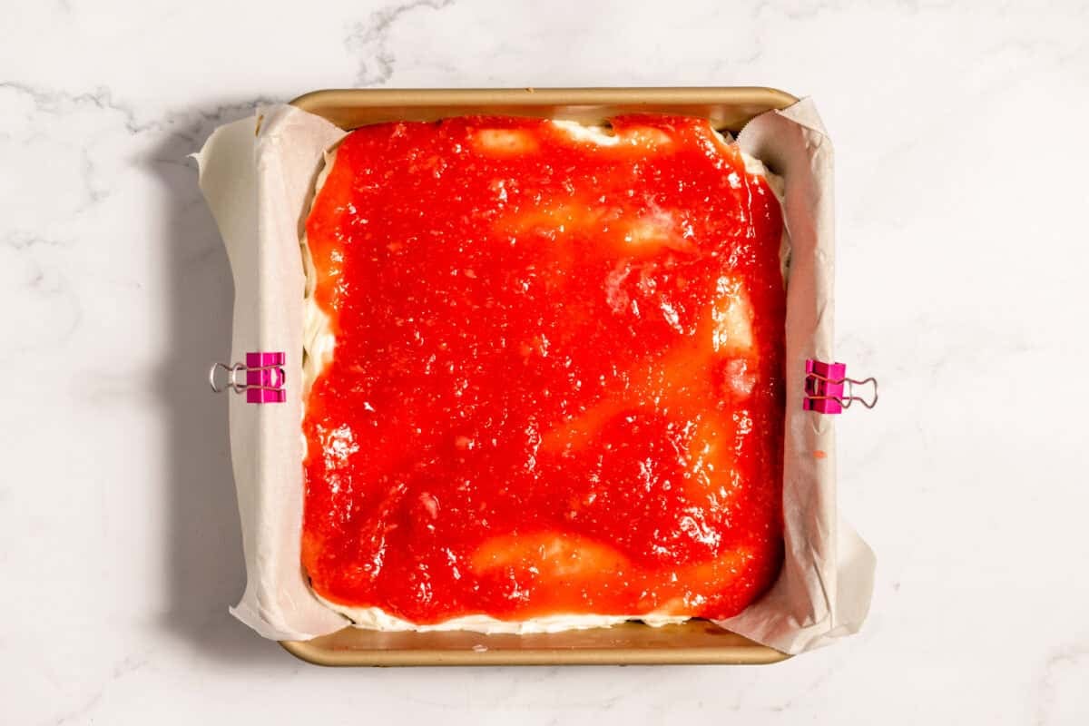 strawberry puree over cream cheese in pan