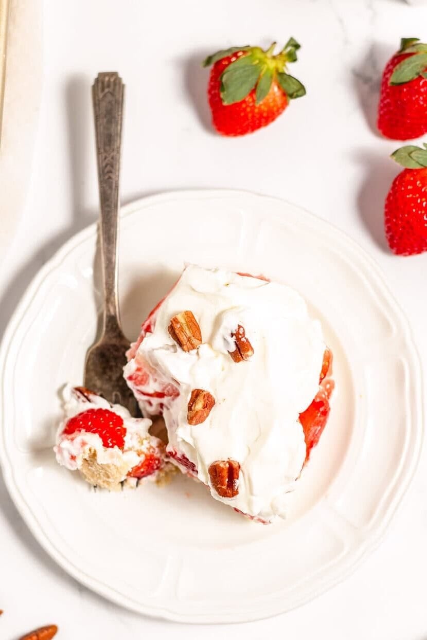 a sliced of strawberry delight on a white plate