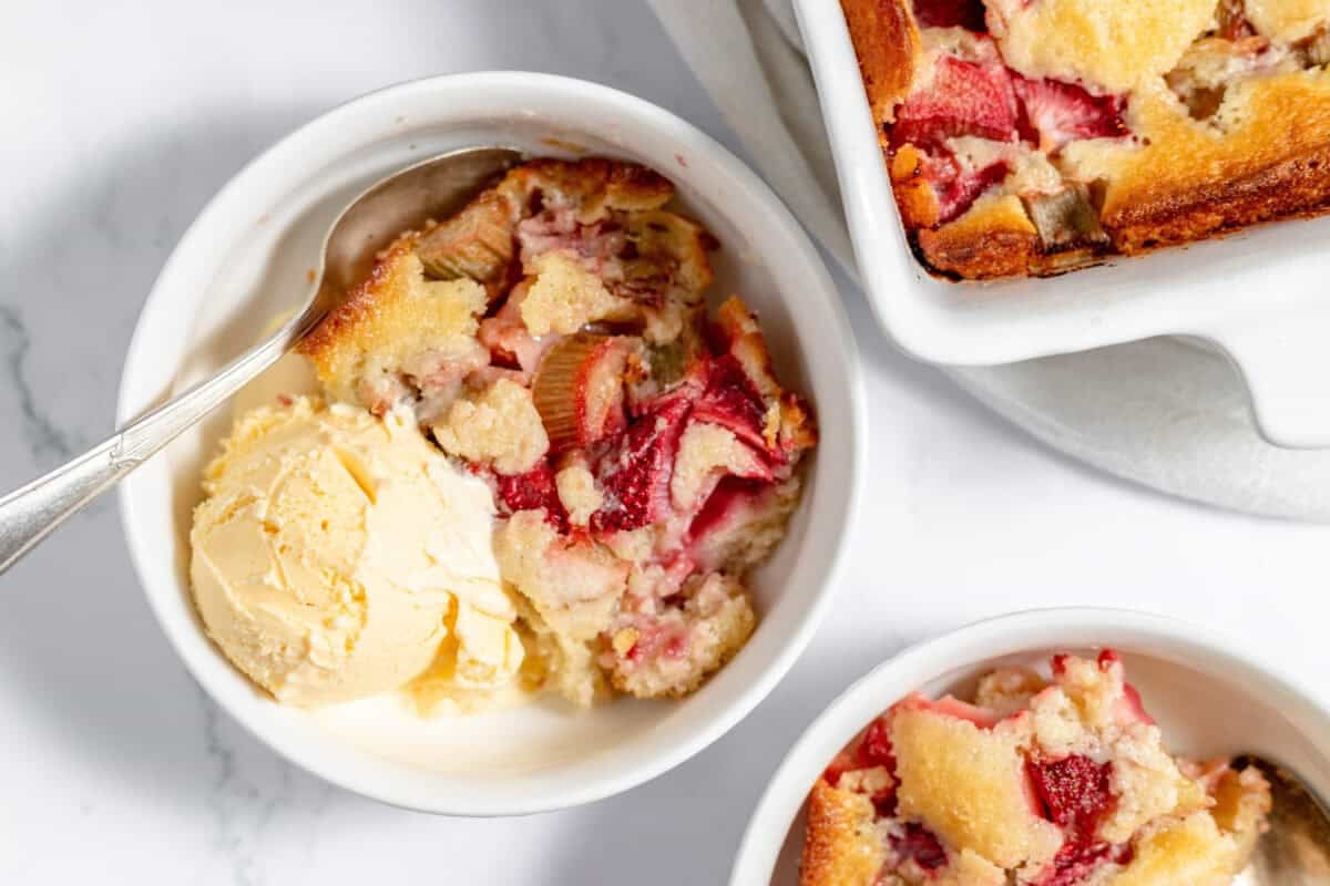 strawberry rhubarb cobbler in a bowl with vanilla ice cream
