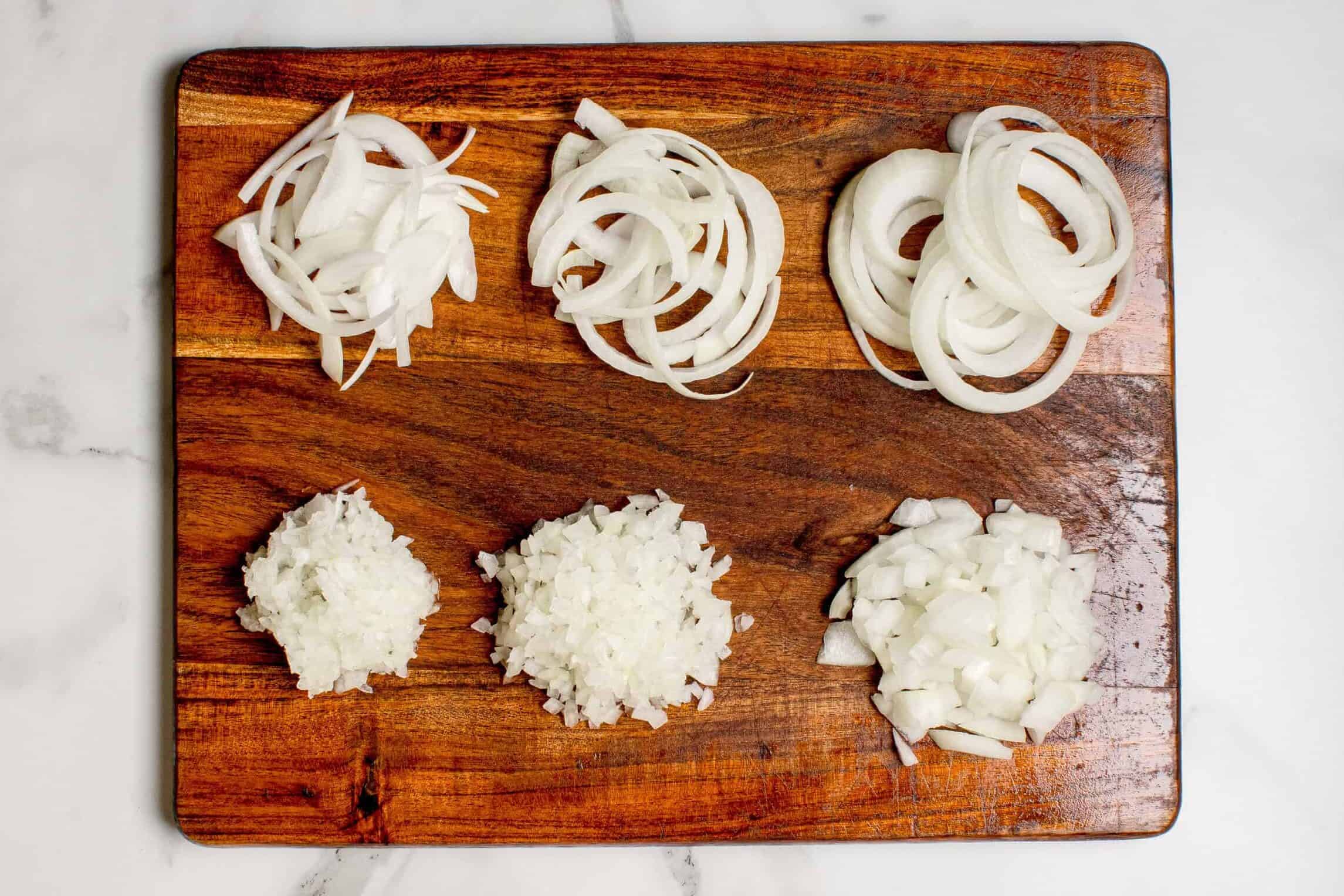 onions cut up 6 different ways on a cutting board