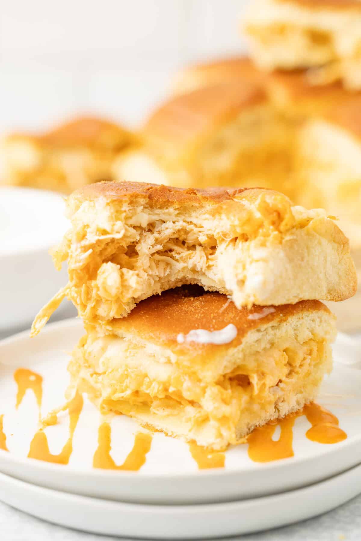 buffalo chicken sliders with a bite missing and ranch dressing