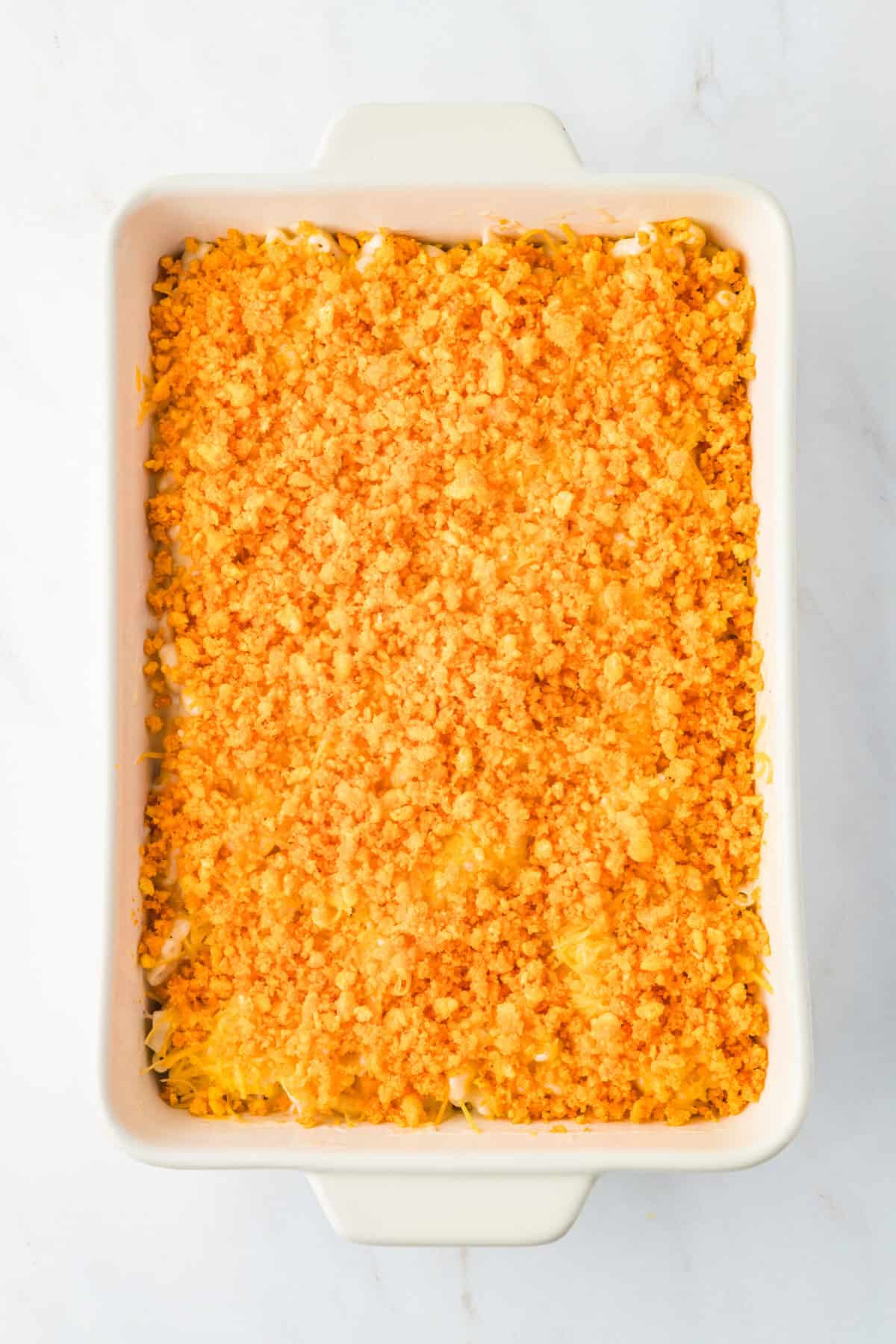 crushed cheetos over mac and cheese in a baking dish