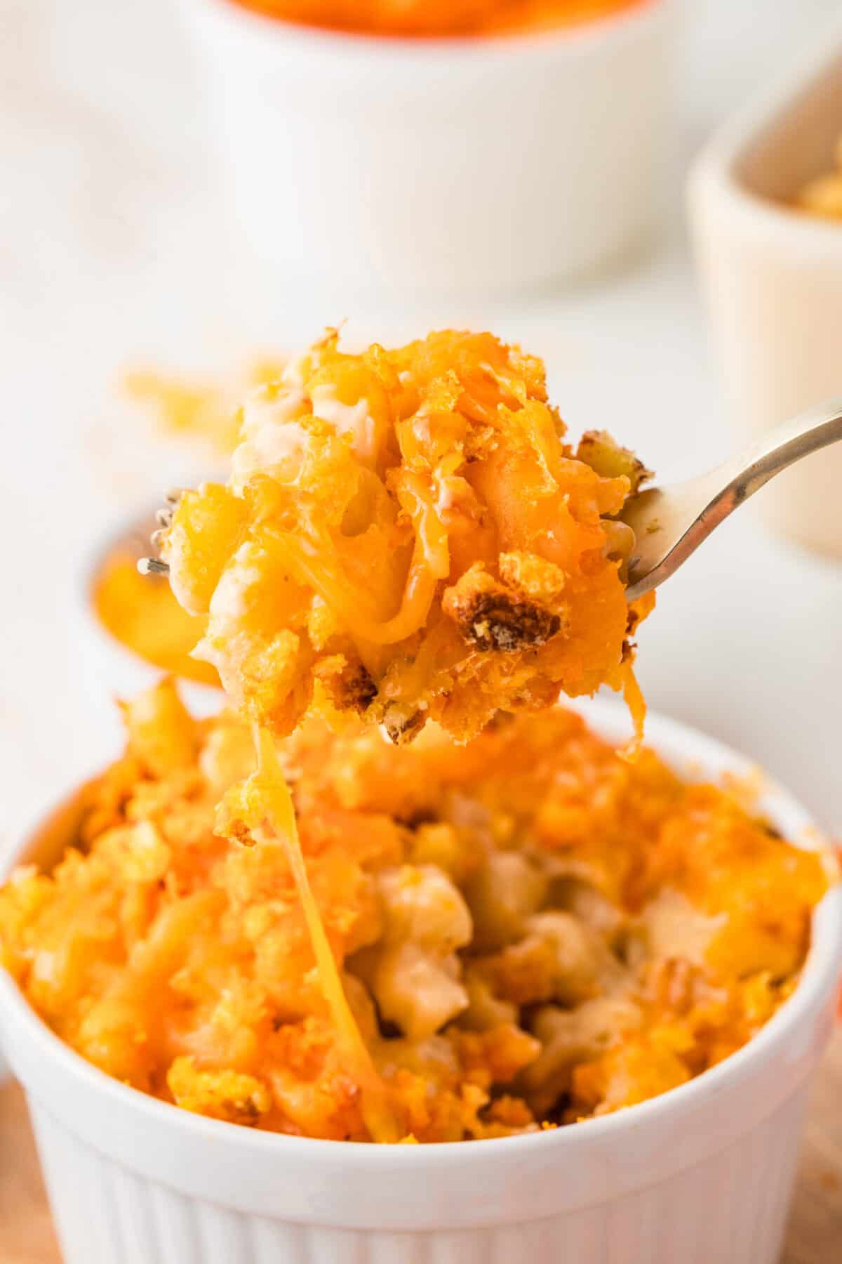 Cheetos Mac and Cheese in   a bowl and being lifted with a fork