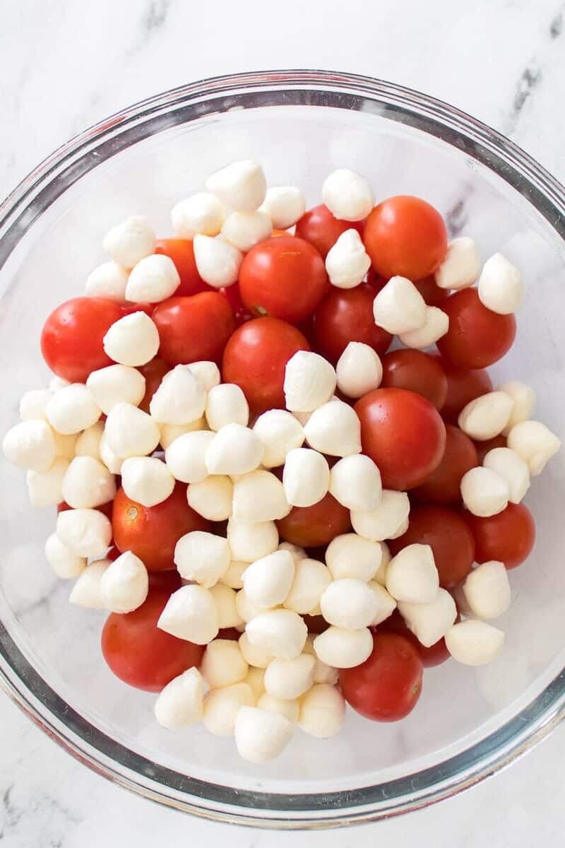 tomatoes and mozzarella balls tossed together in a large mixing bowl
