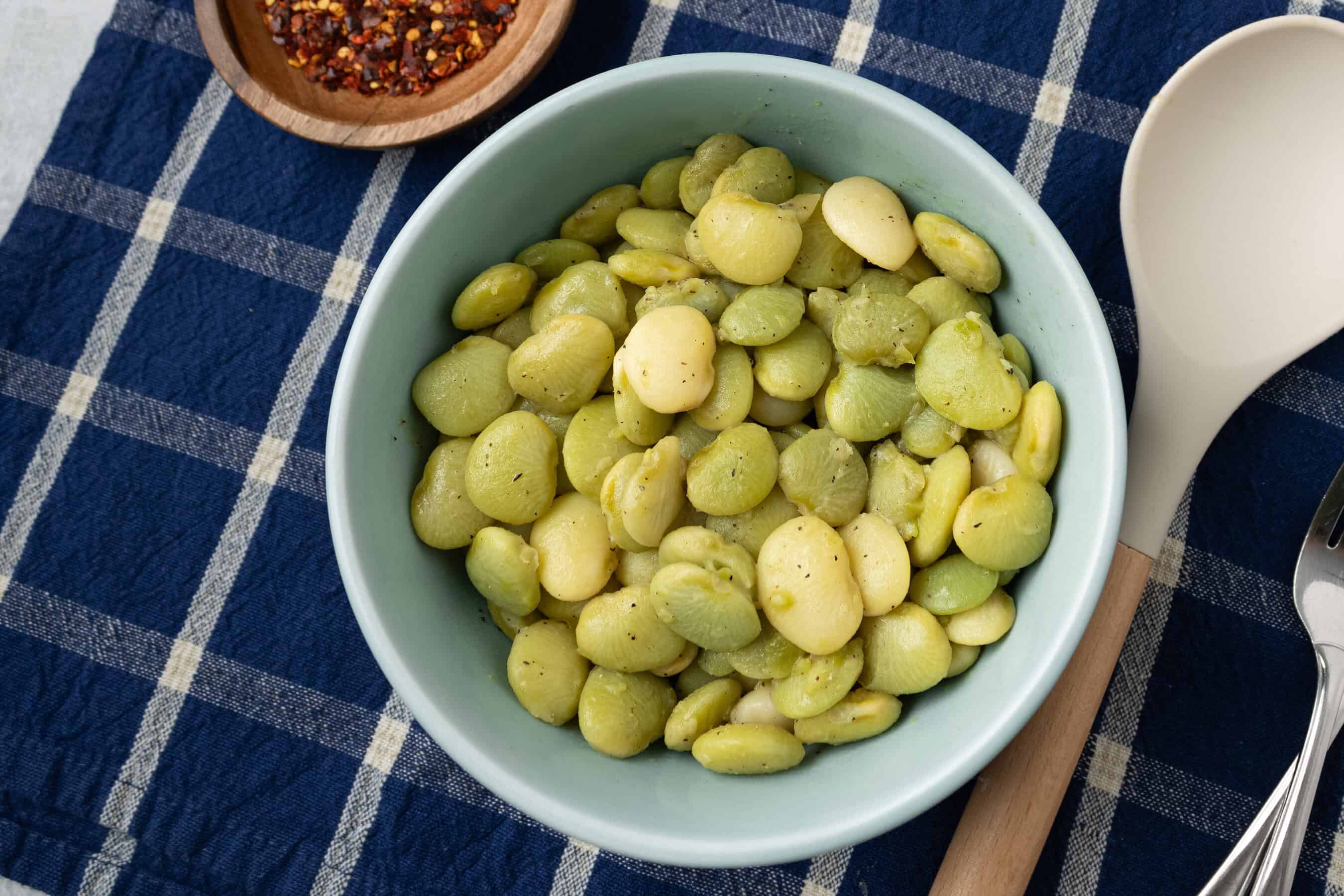 bowl of butter beans next to bowl of red pepper flakes