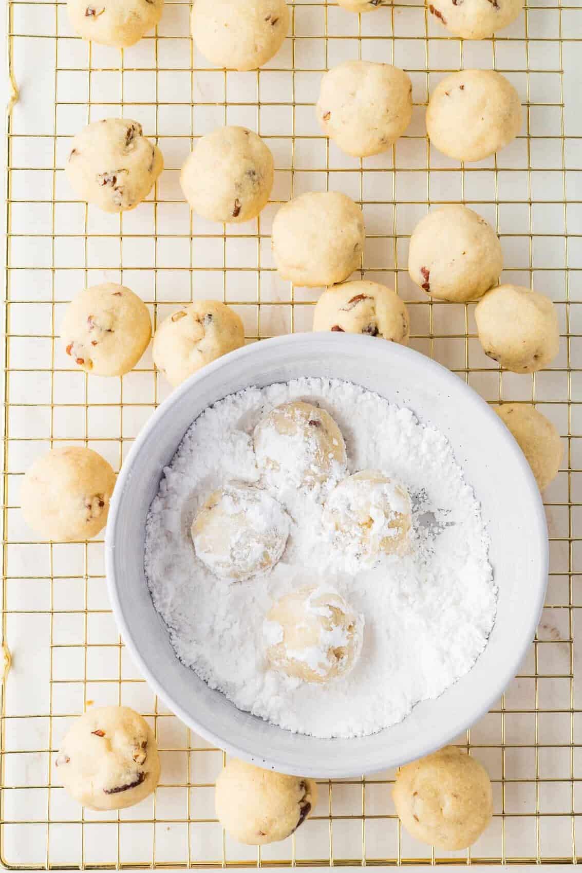 cookies in bowl of powdered sugar