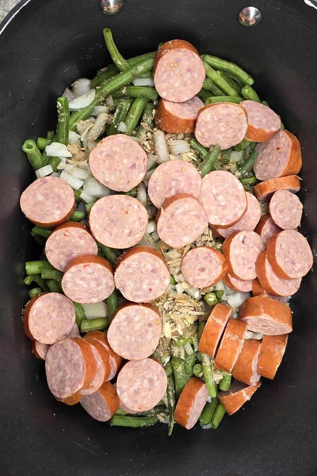 cut up smoked sausage on top of everything in the slow cooker pot