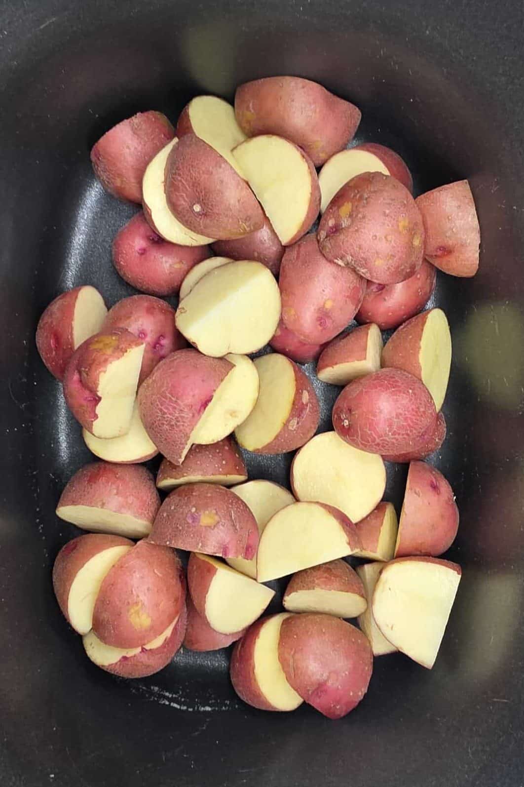cut up red potatoes in a crockpot