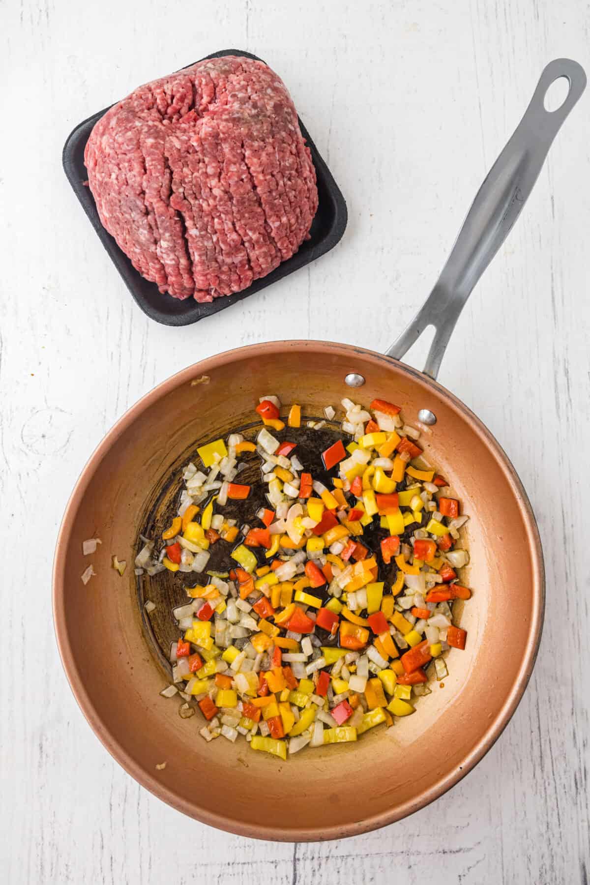 sauteing peppers and onions in a skillet