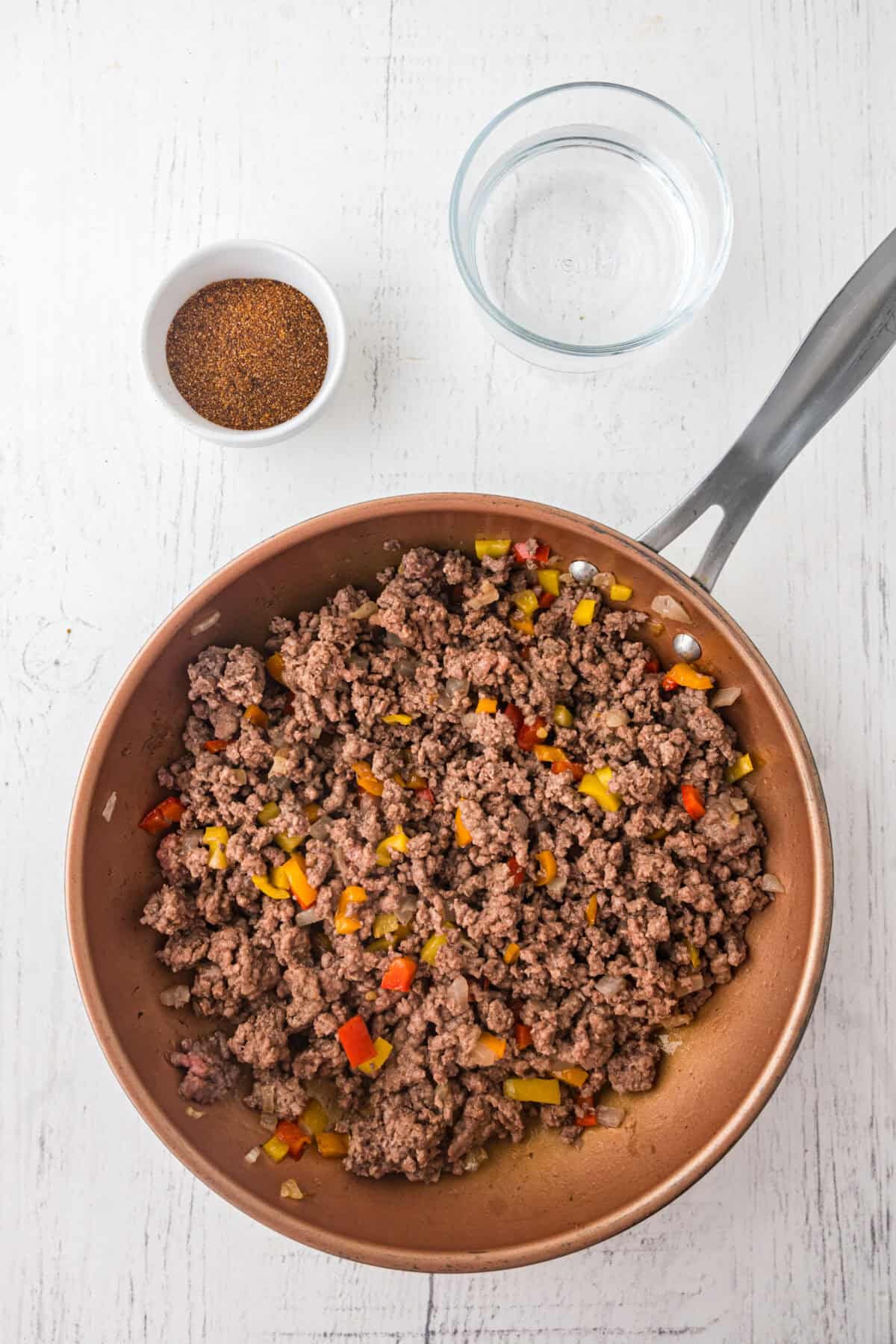 browned meat with veggies in a skillet