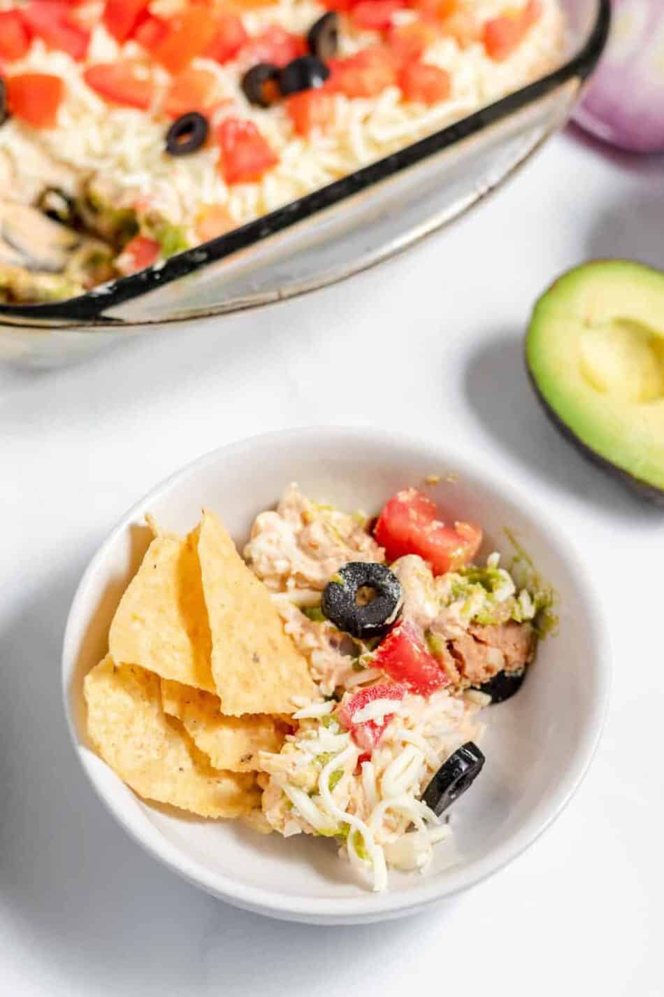 7 layer dip in a bowl with tortilla chips