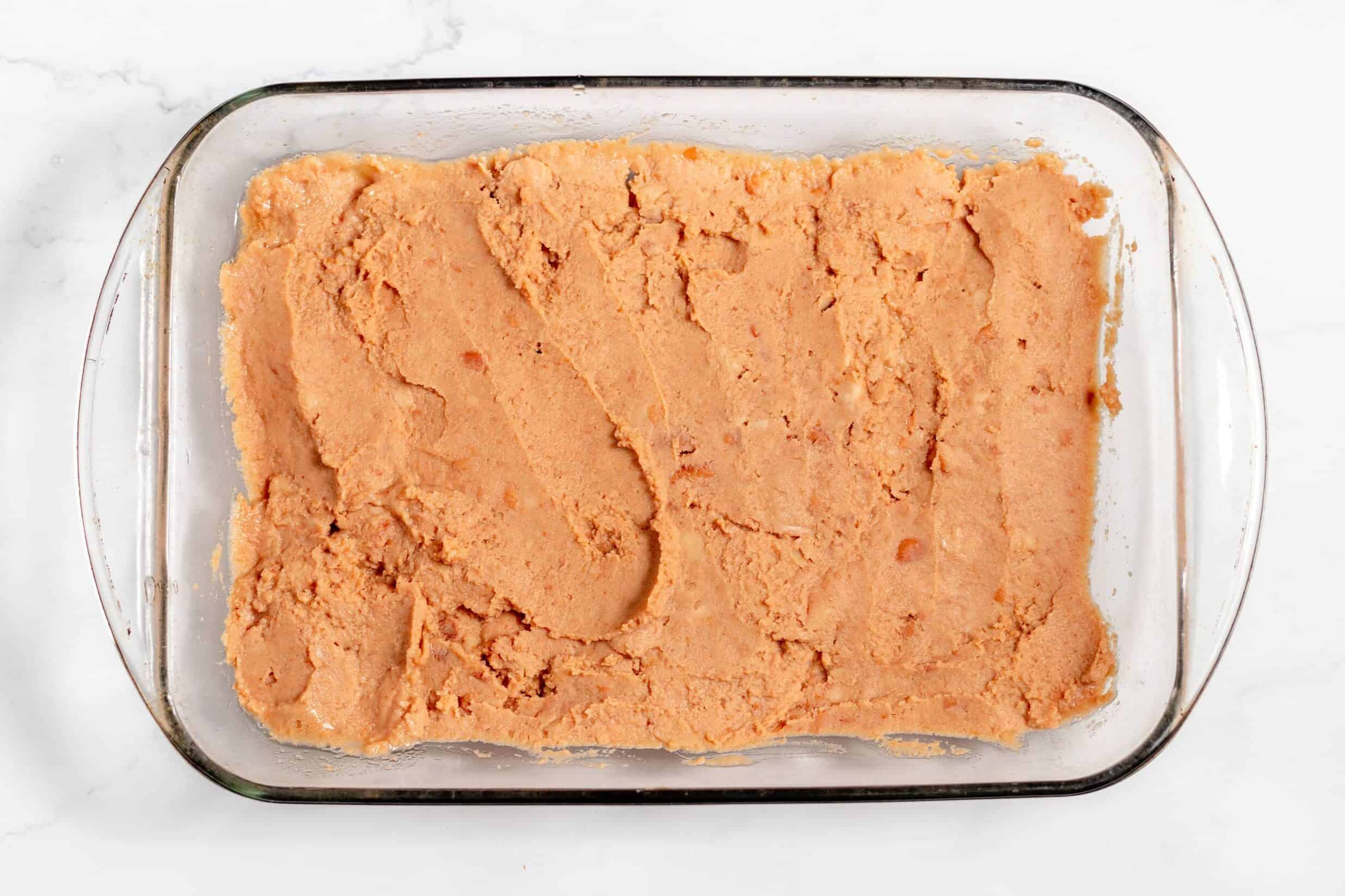 refried beans in bottom of 9x13 dish