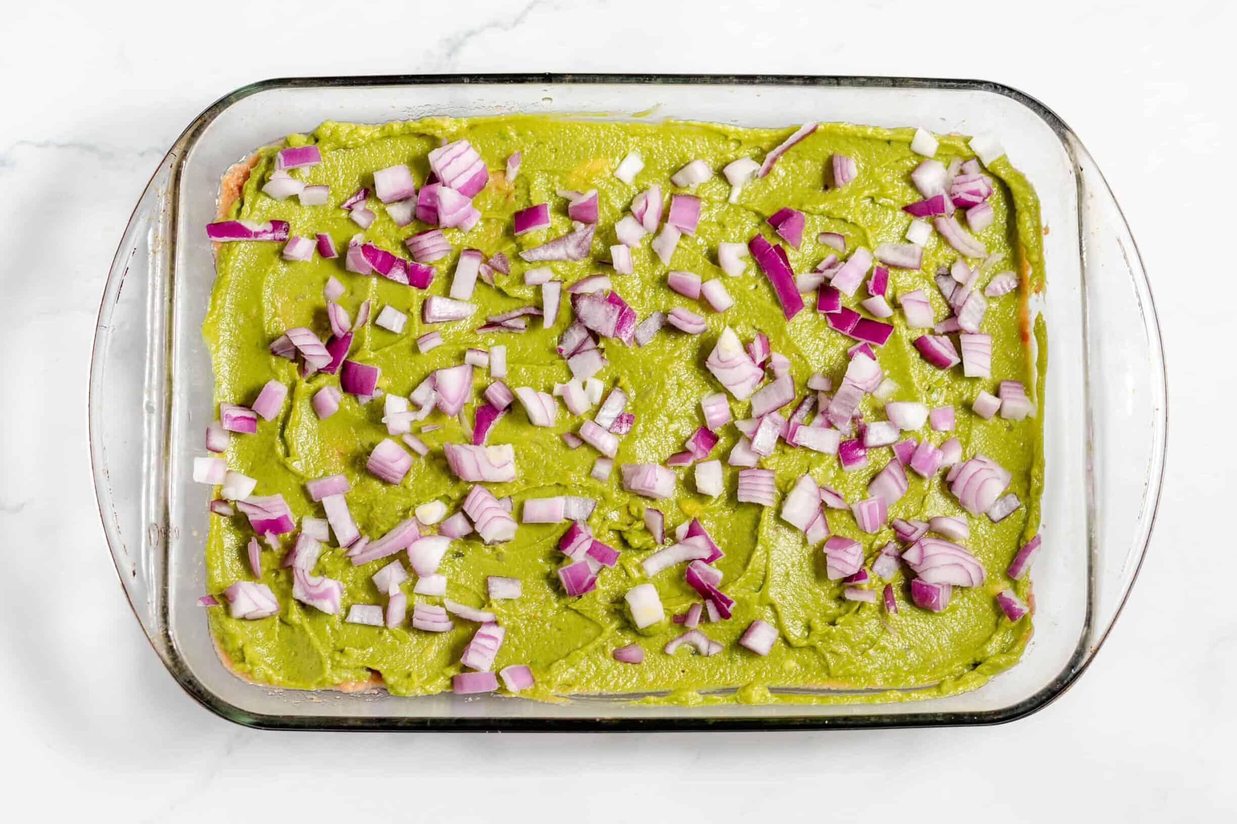 red onions on top of guacamole