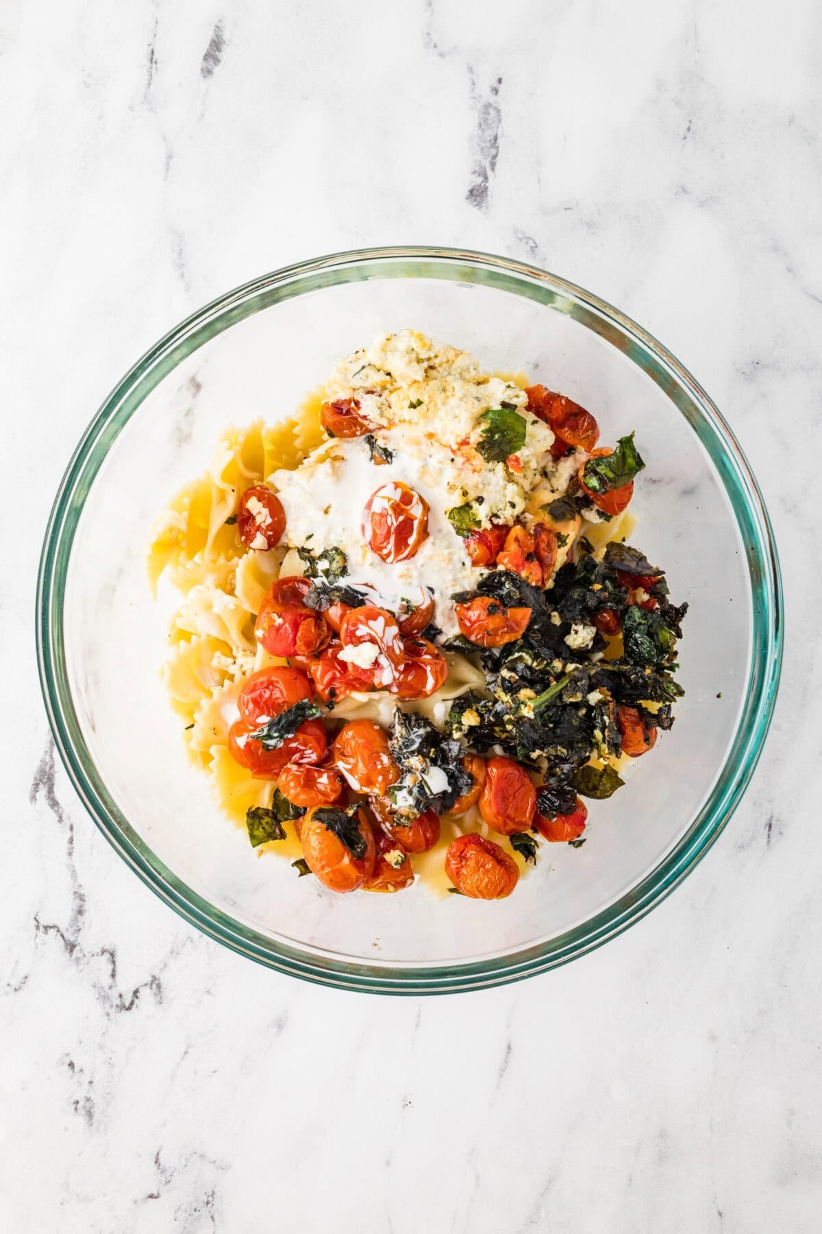 roasted vegetables and cheese added to bowl of pasta