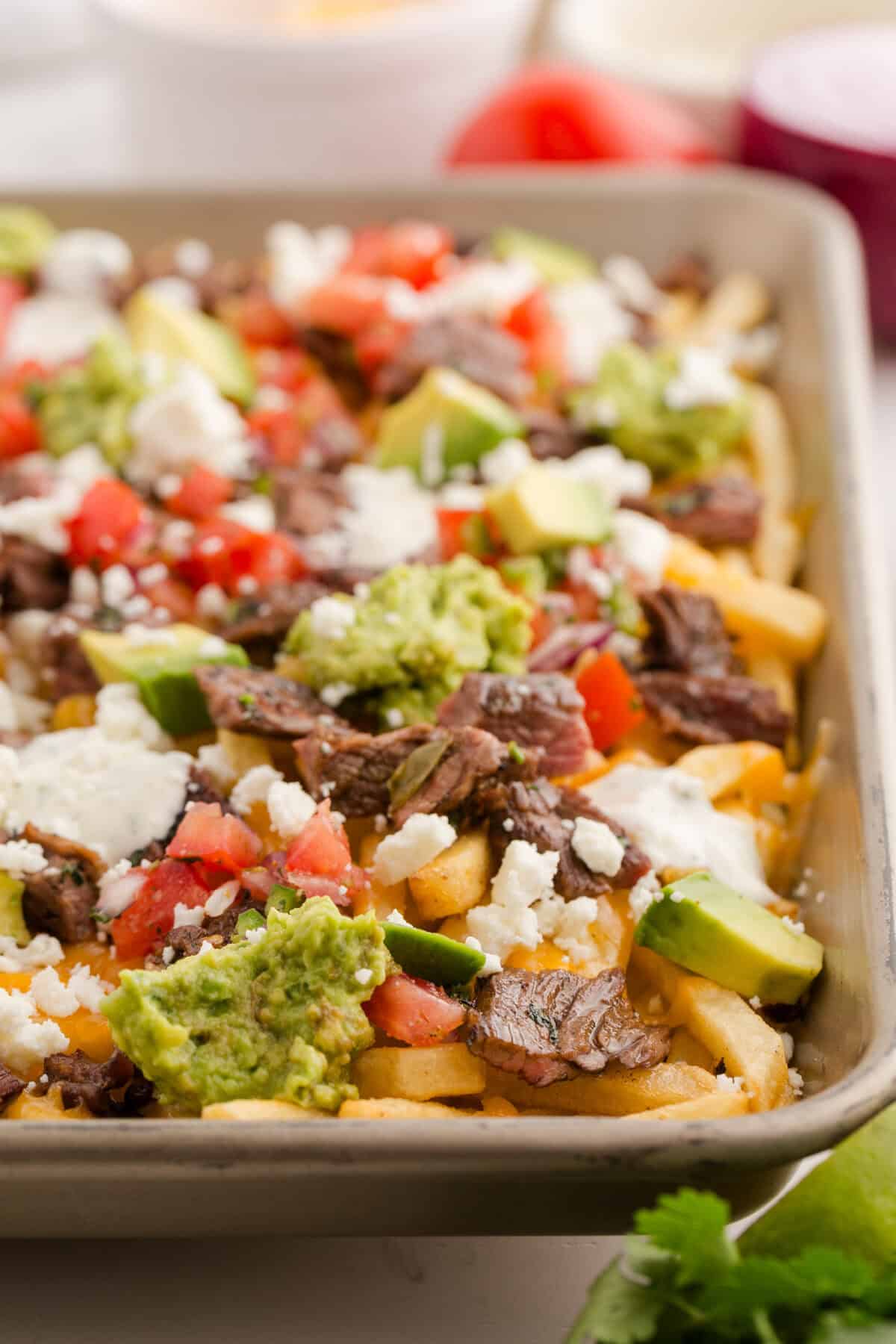 carne asada fries on a baking sheet