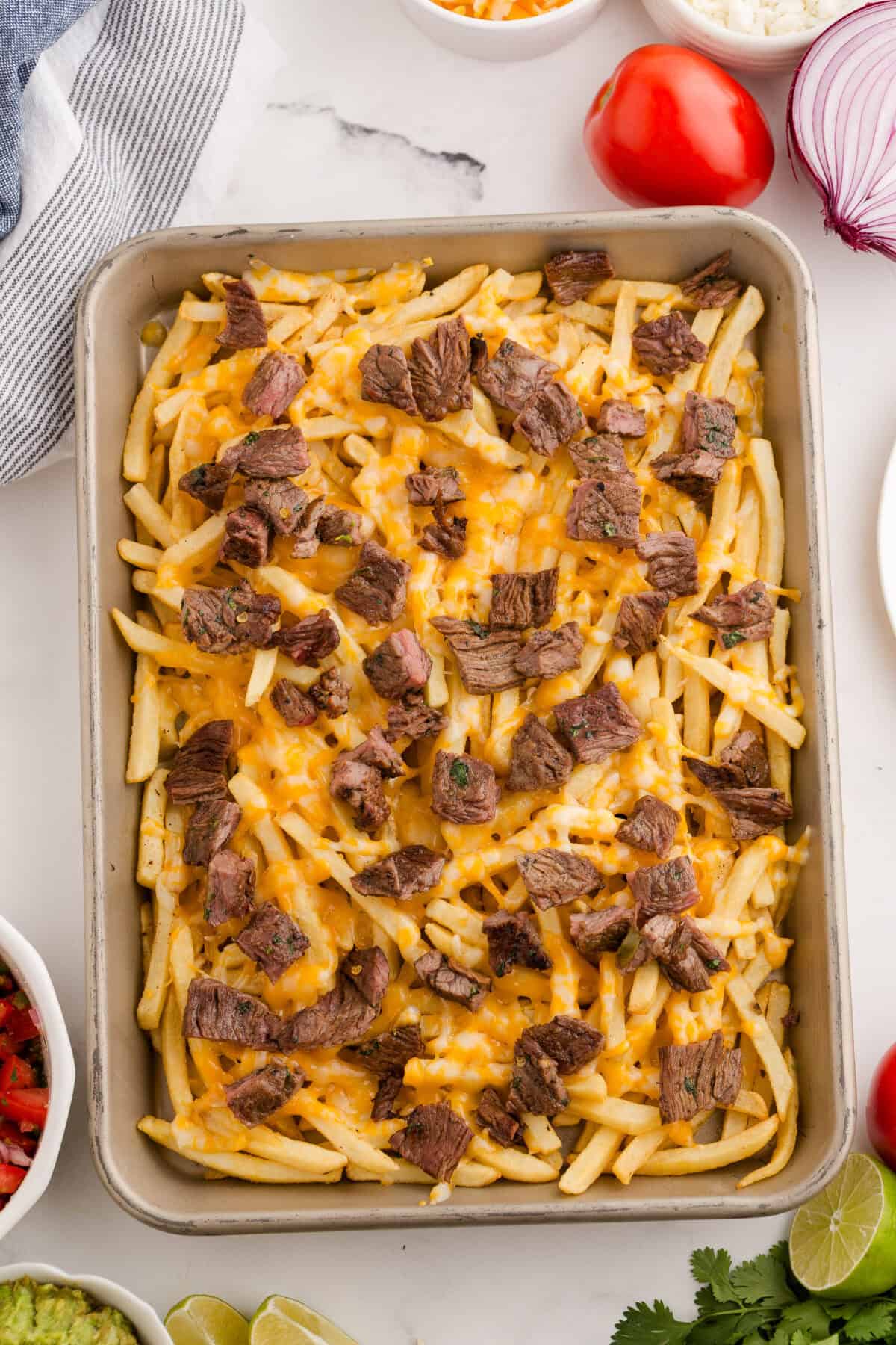 melted cheese and heated carne asada over fries