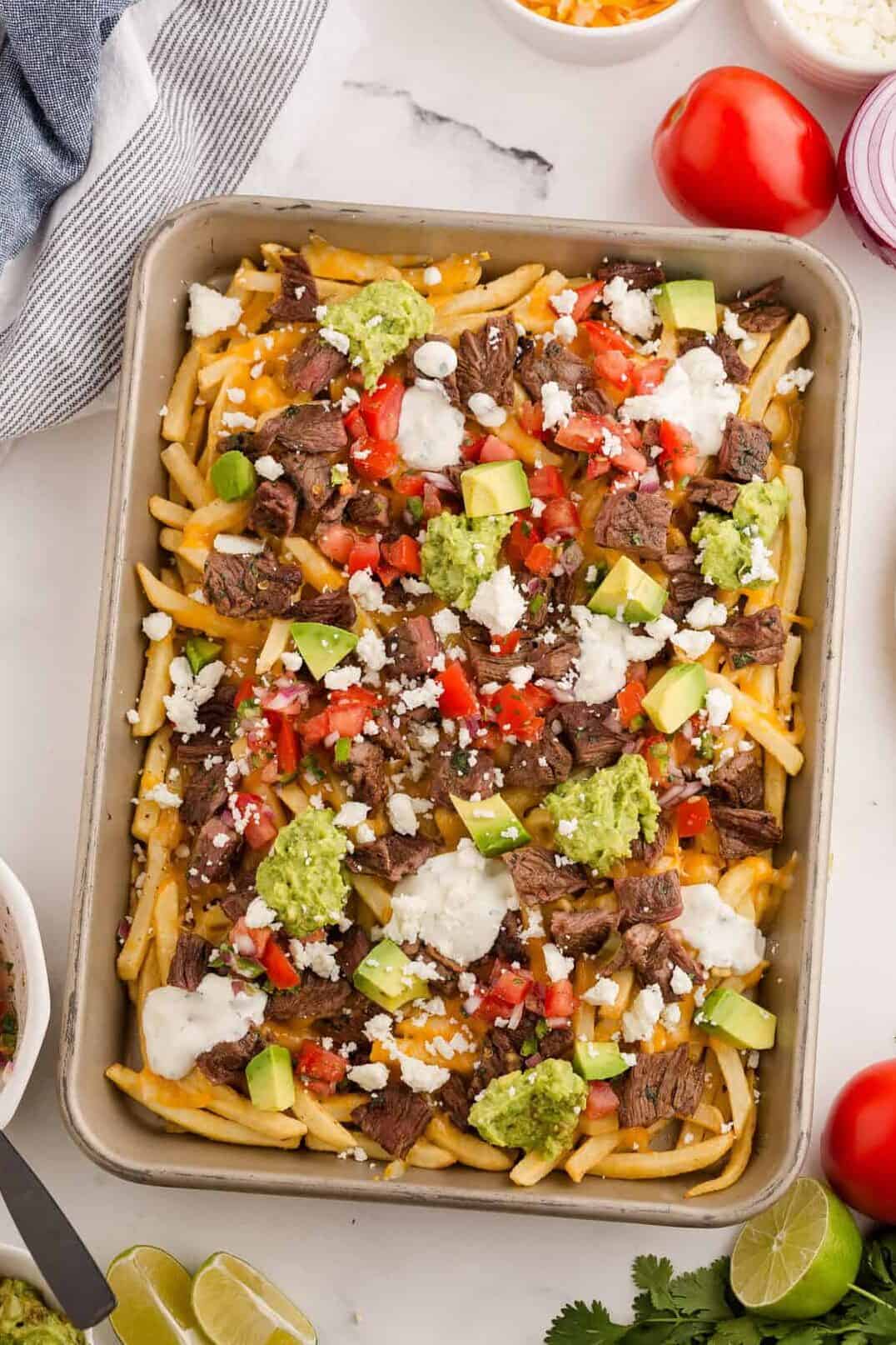 carne asada fries on a baking sheet