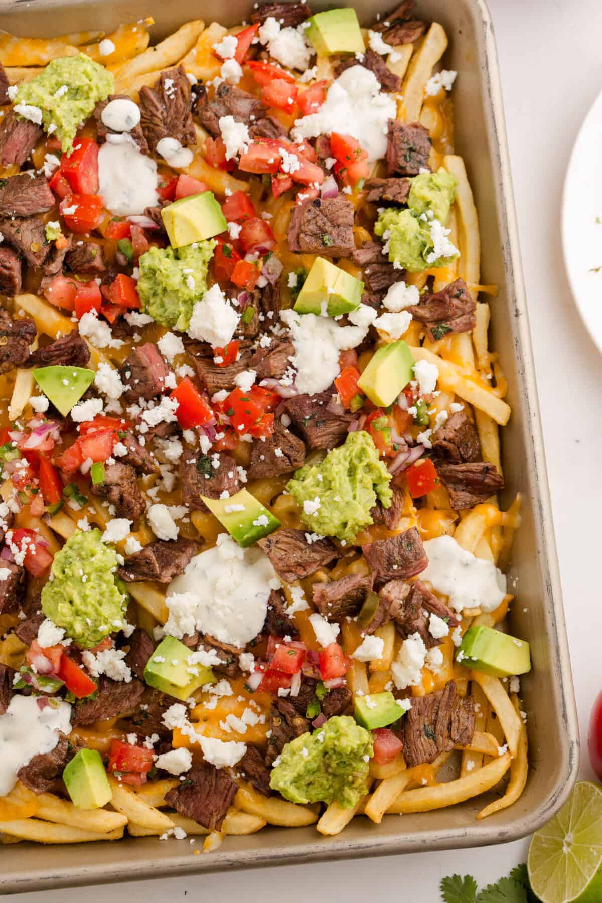 carne asada fries on a baking sheet