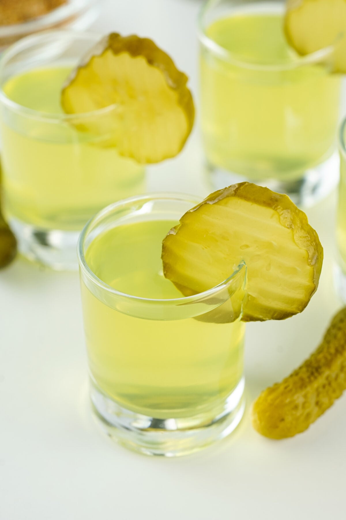 dill pickle shots with a slice of pickle for garnish
