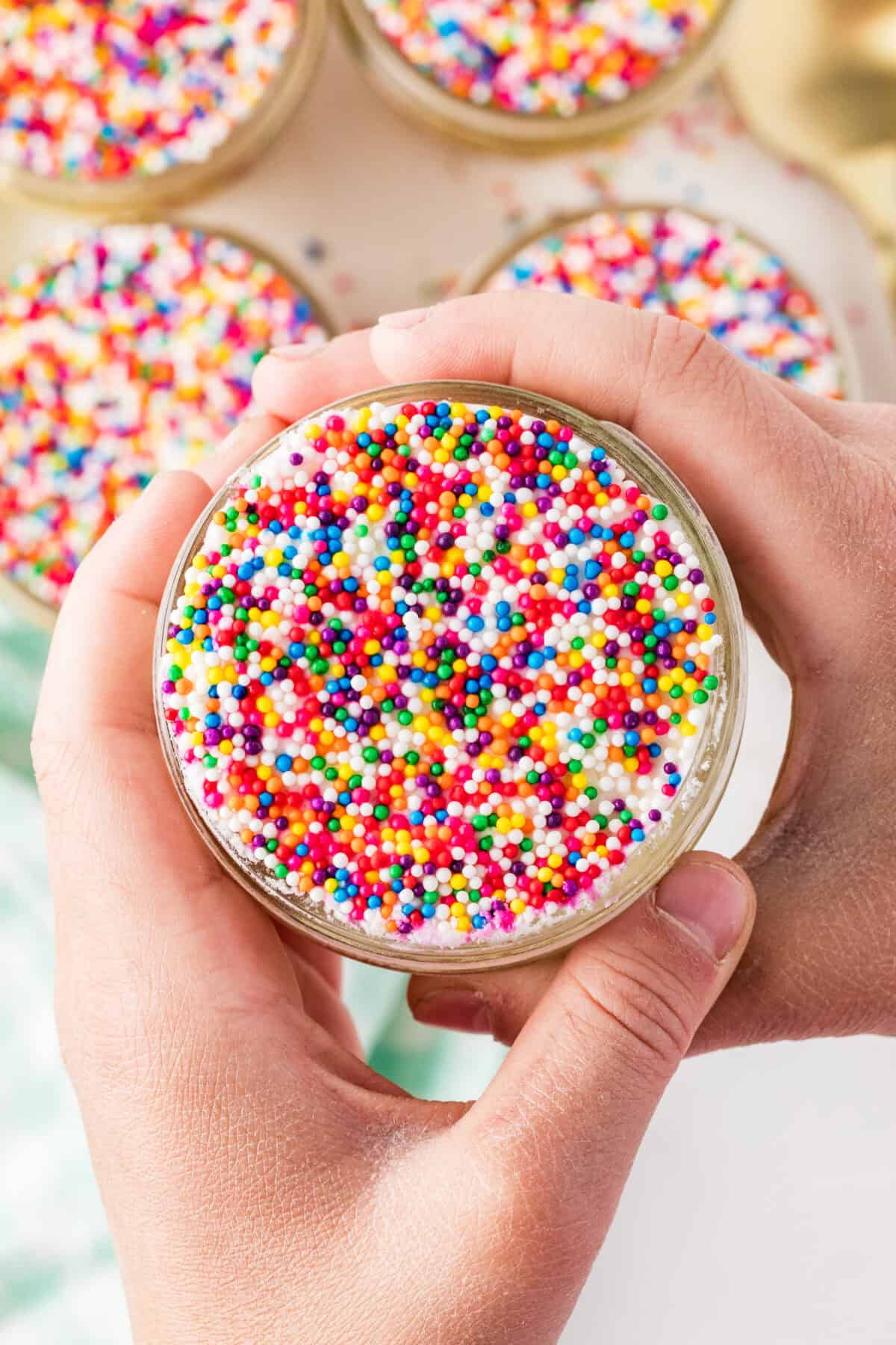 small hands holding dots cake