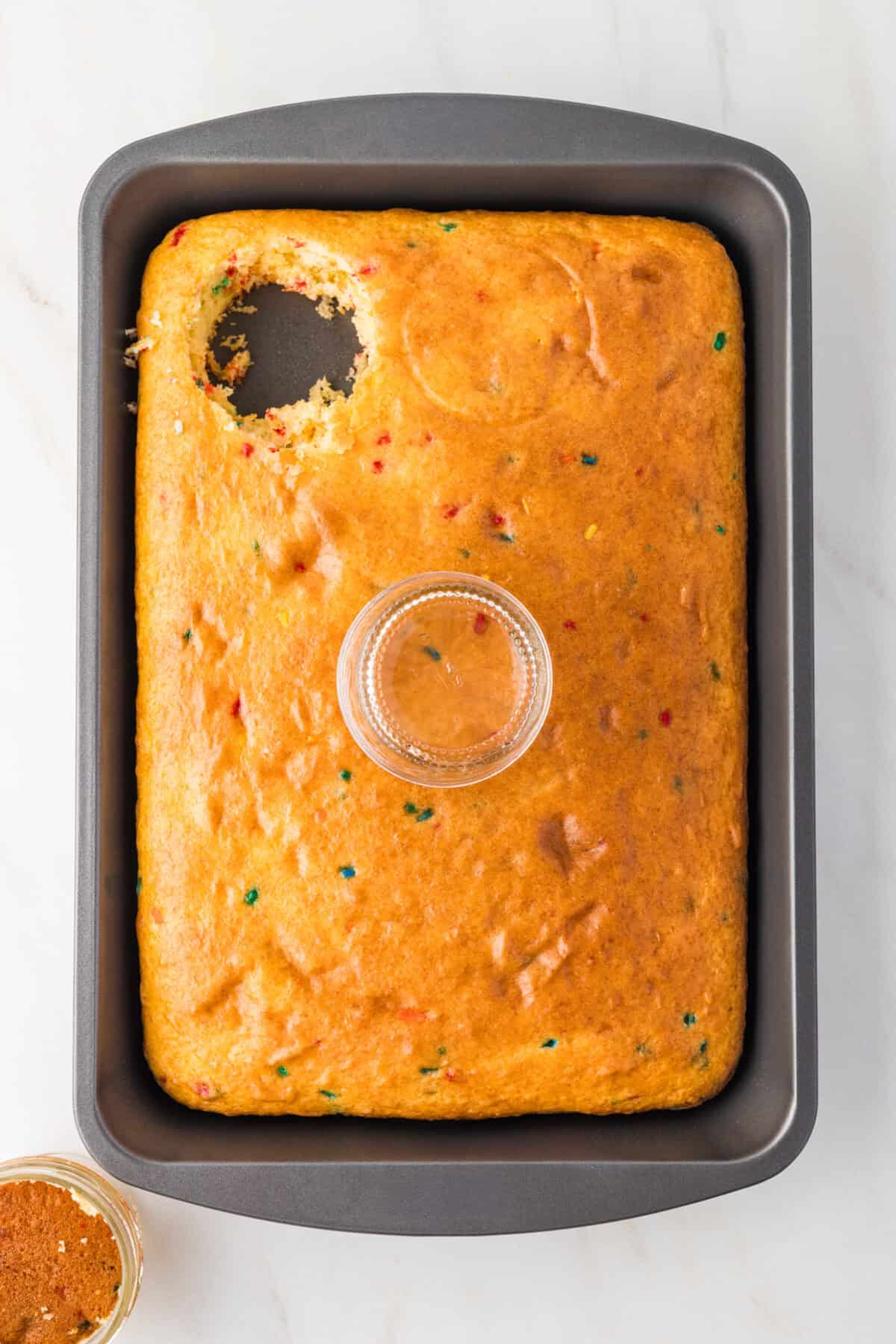 cutting dot cake out of sheet cake with a 4 oz mason jar