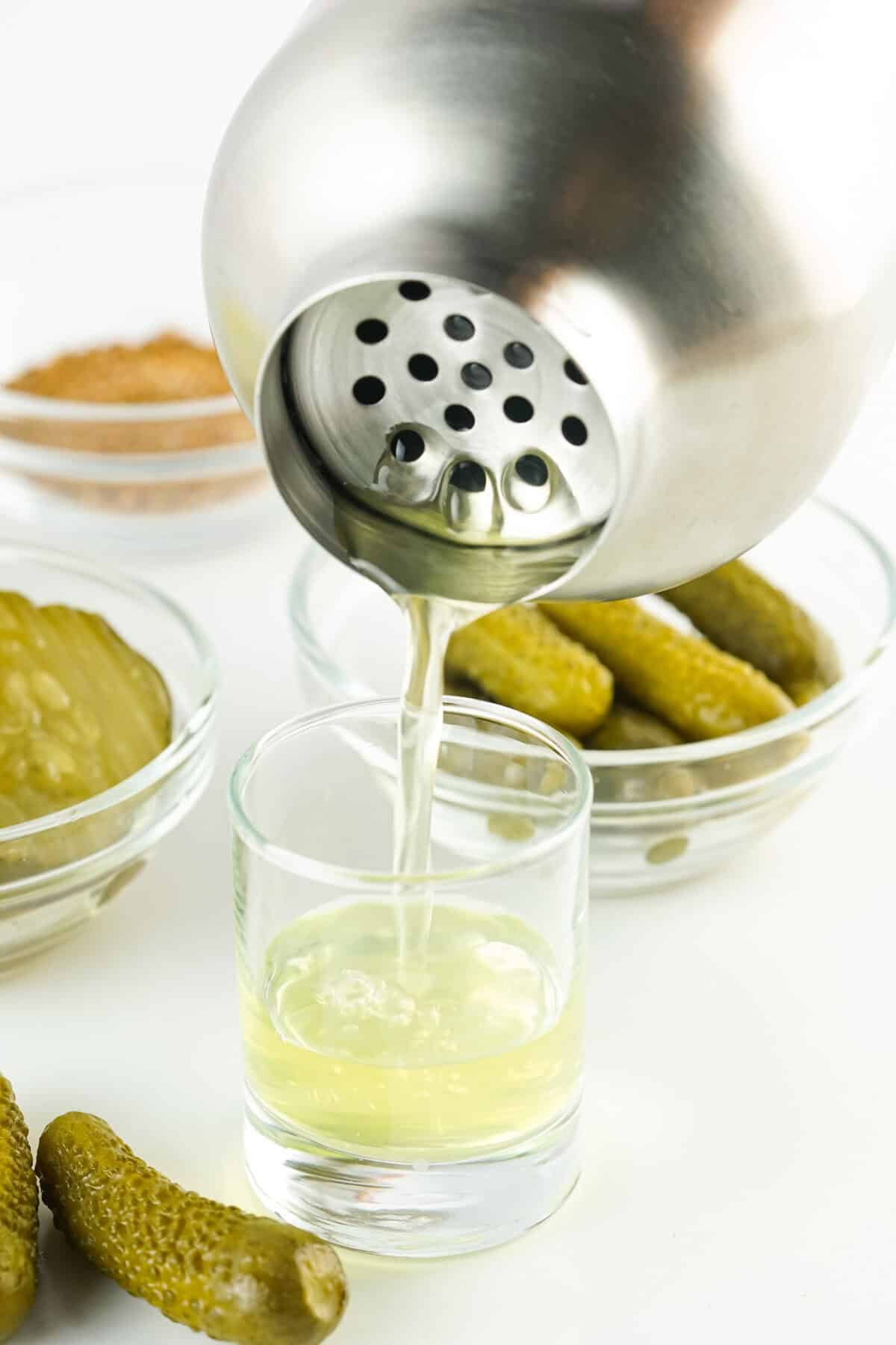 pouring pickle shots into shot glasses