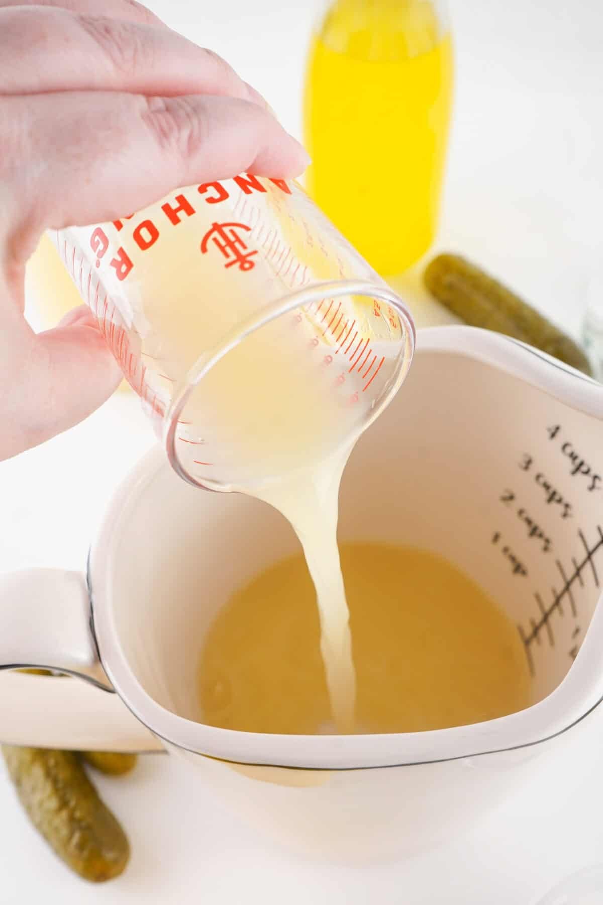 lemon juice being poured into measuring cup
