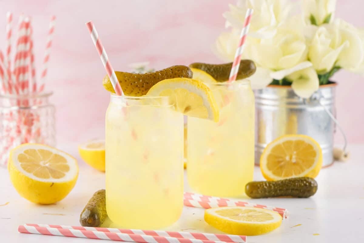 dill pickle lemonade in a mason jar with pink straws