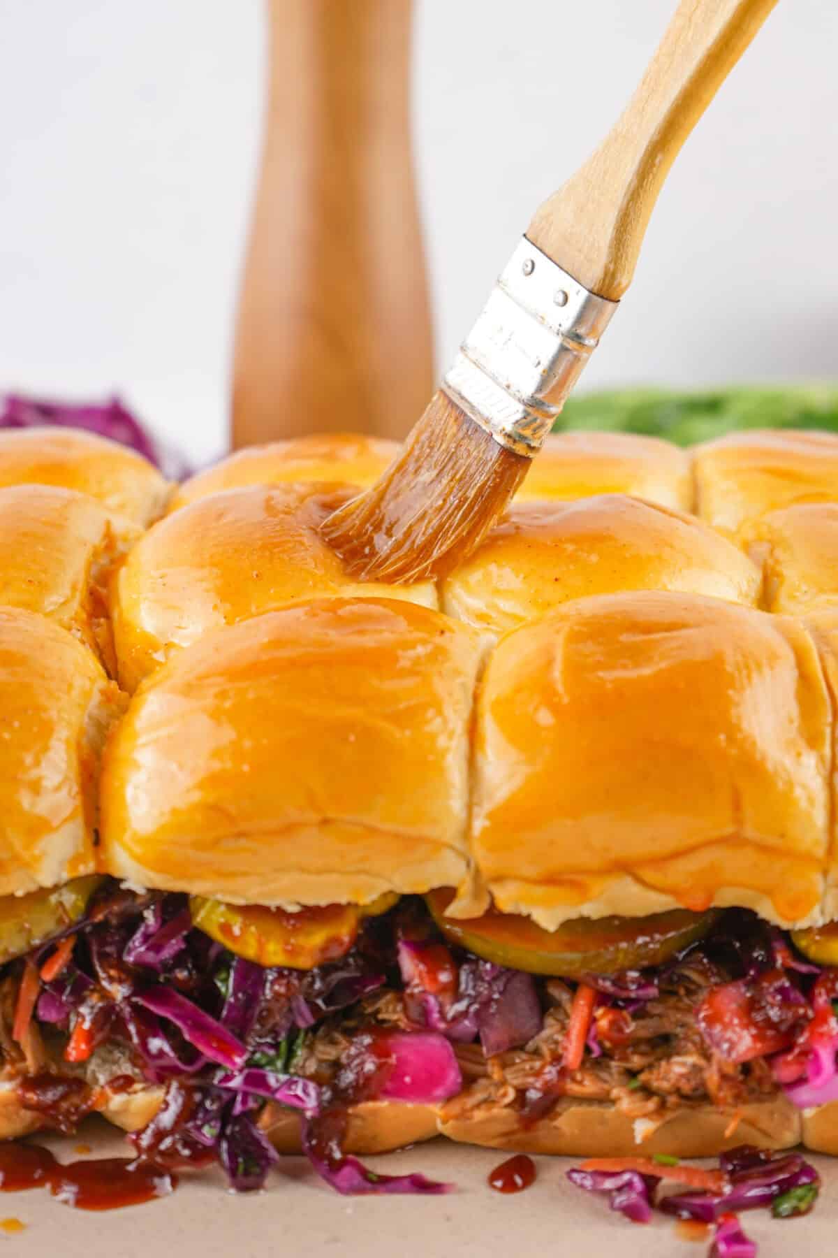 brushing butter and bbq seasoning over buns