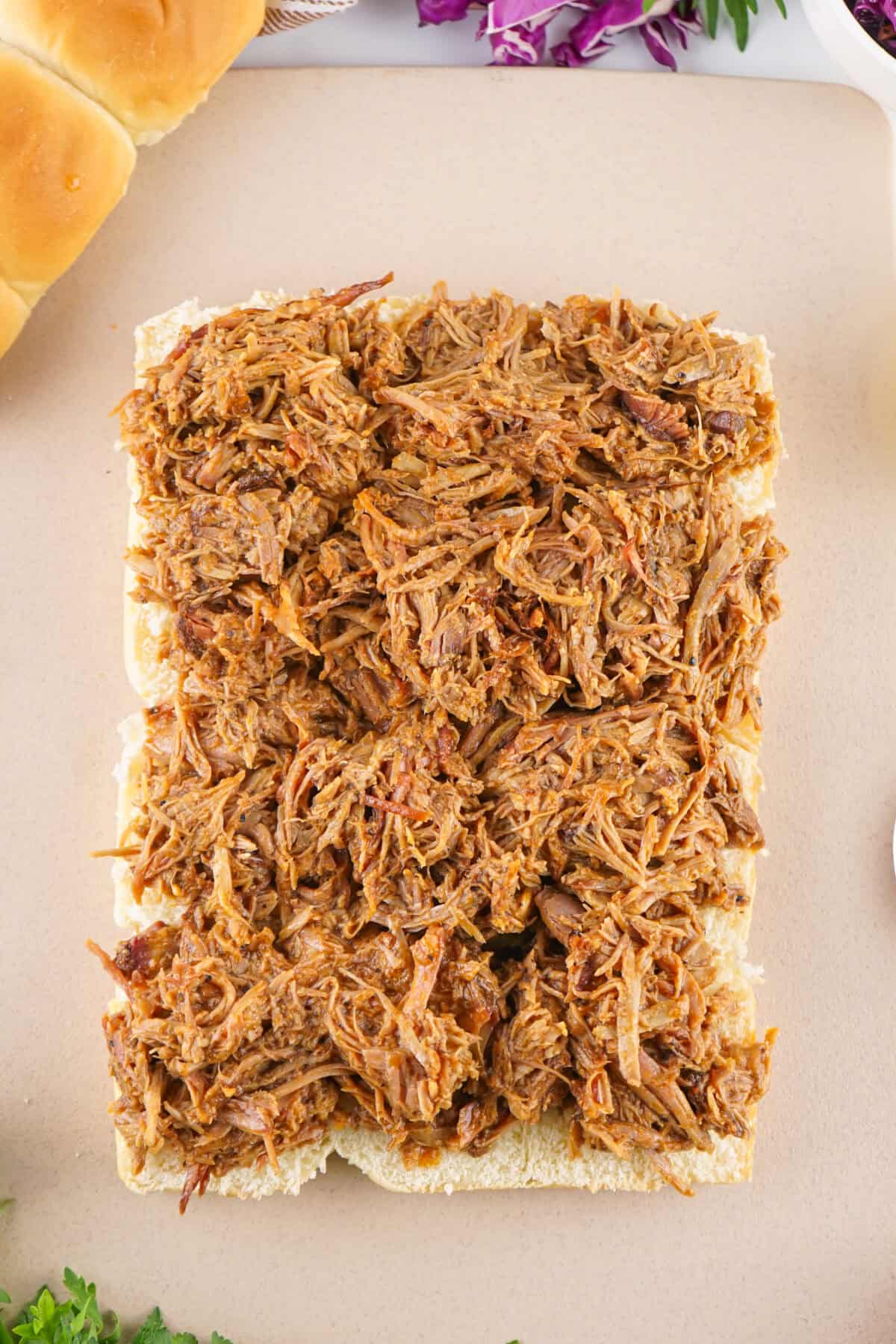 pulled pork spread over hawaiian rolls