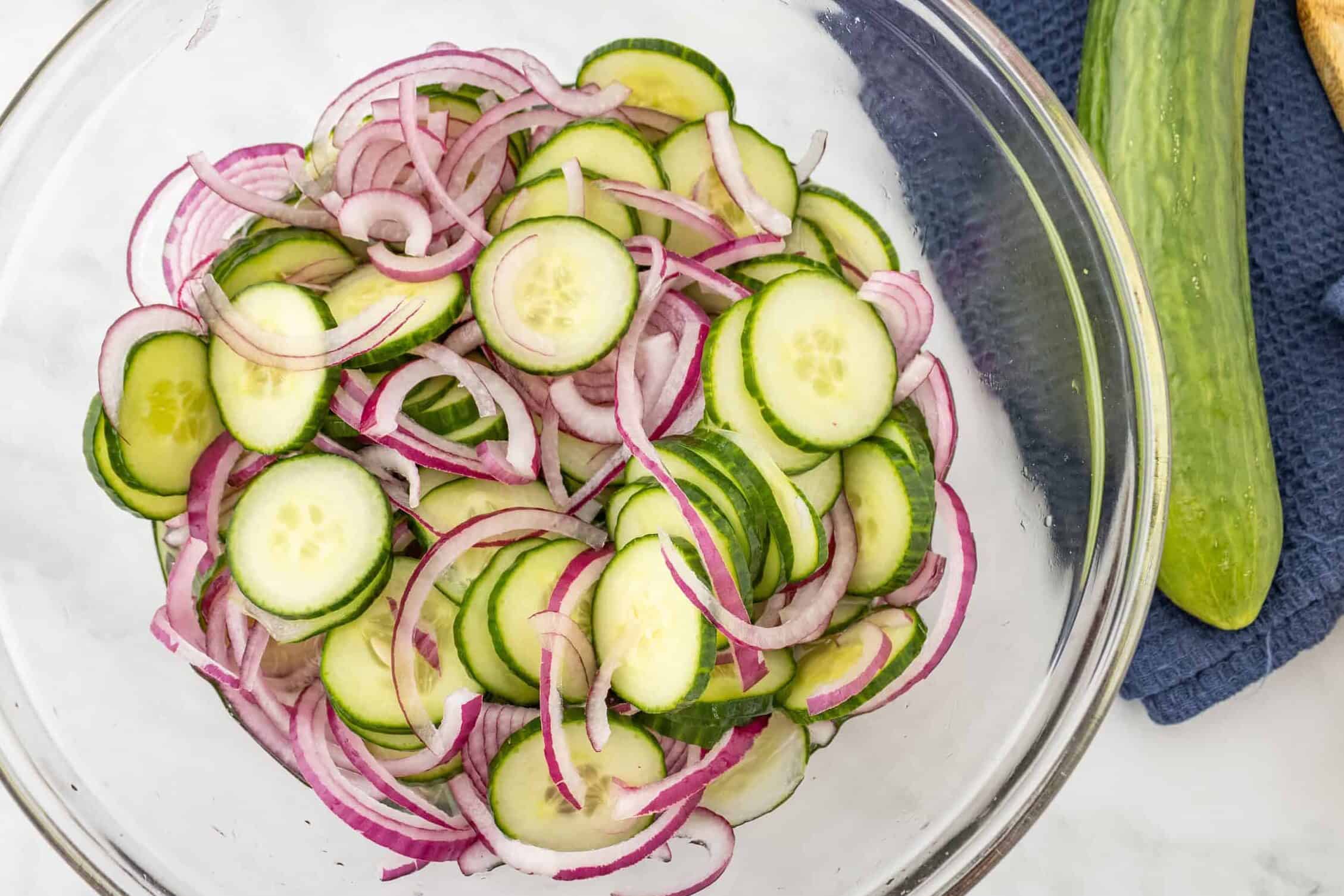 cucumbers and onions in a clear bowl