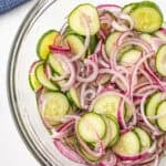 cucumbers and onions in a clear bowl
