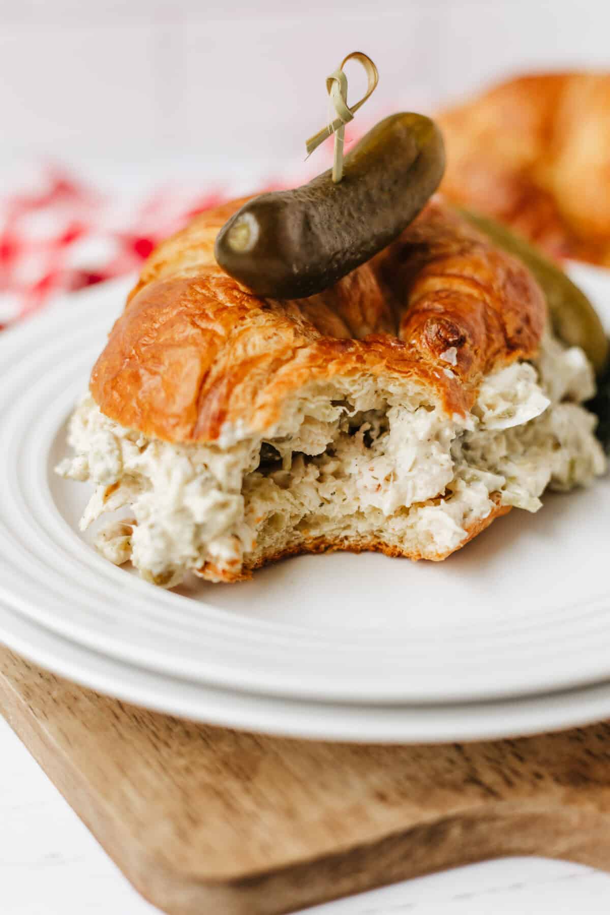 dill pickle chicken salad on a croissant with a bite missing