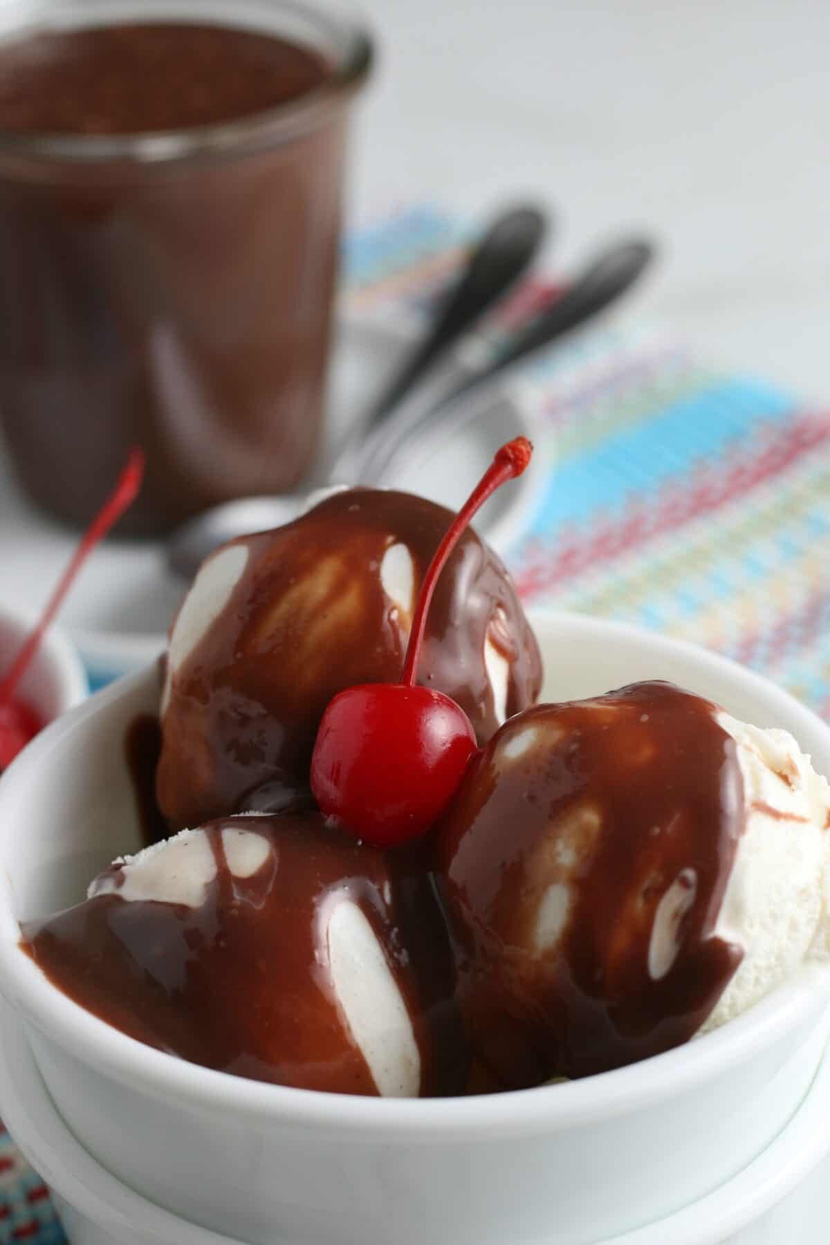 hot fudge sauce over ice cream with a cherry