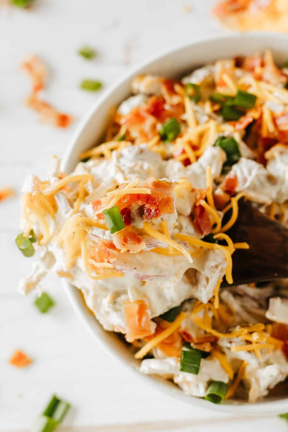 spoon of baked potato salad over a bowl