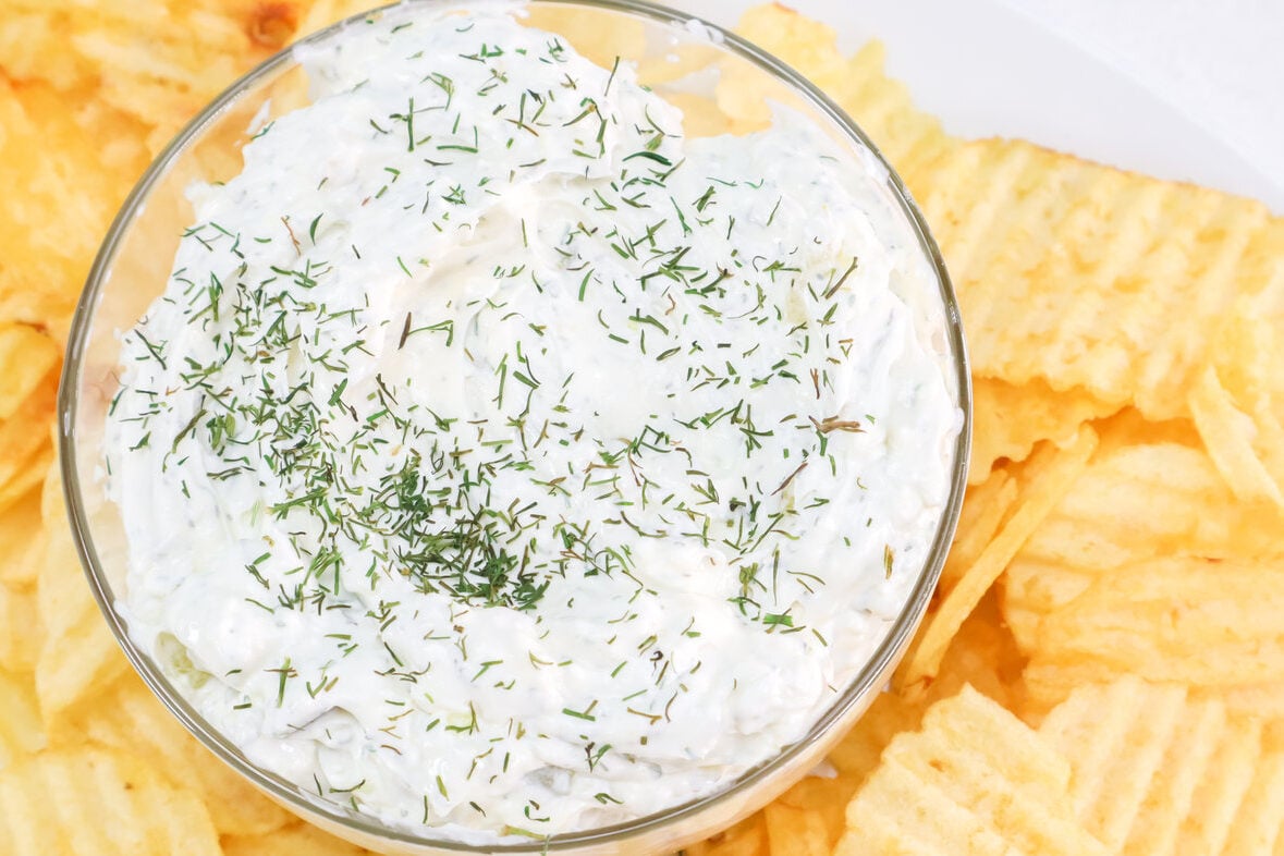 bowl of dill pickle dip surrounded by chips