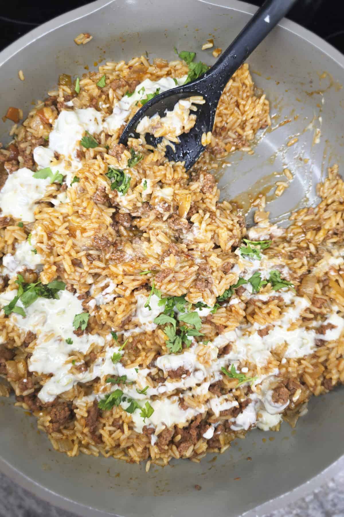 taco rice in skillet with spoon