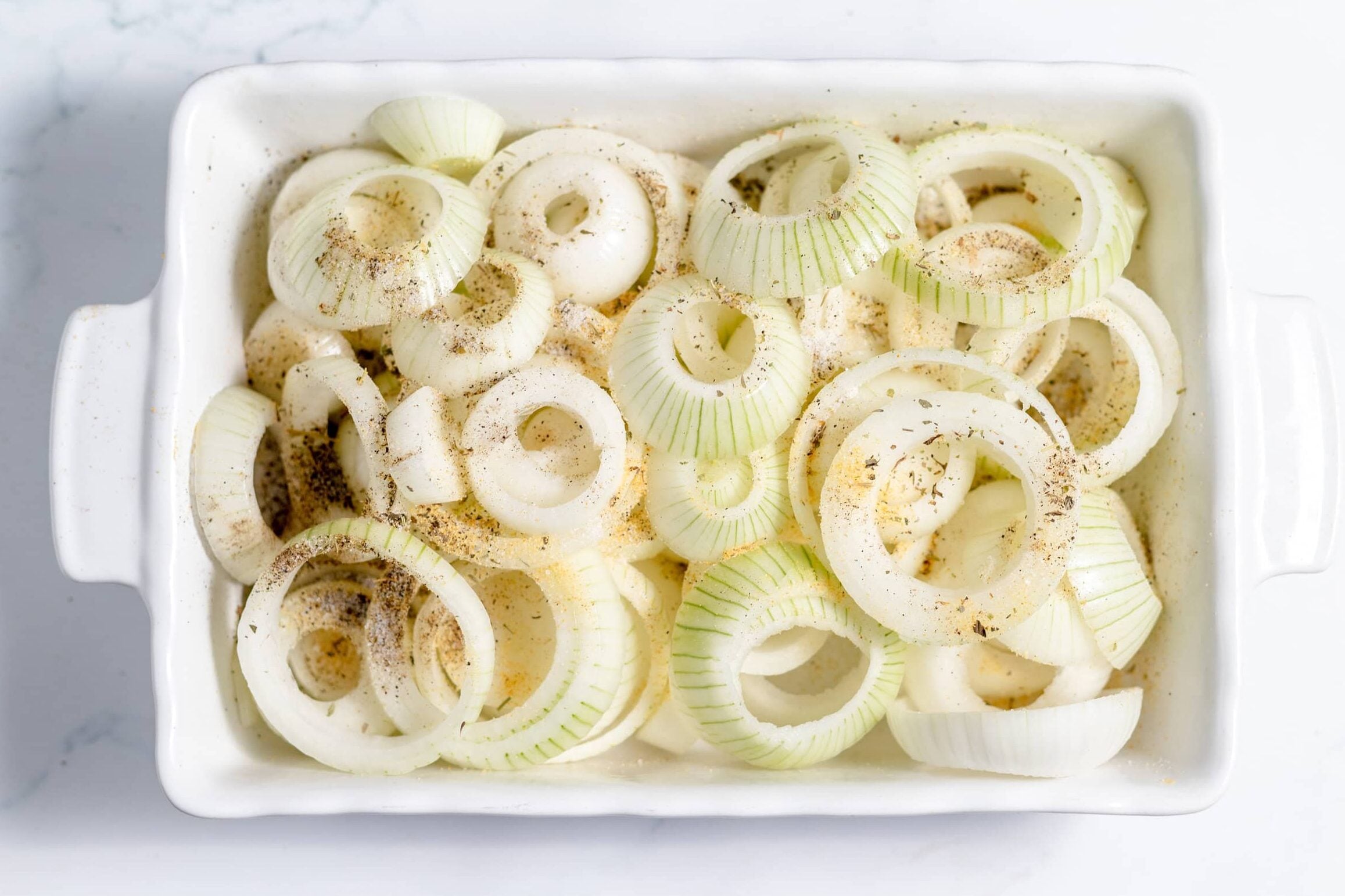 sliced onions in a baking dish